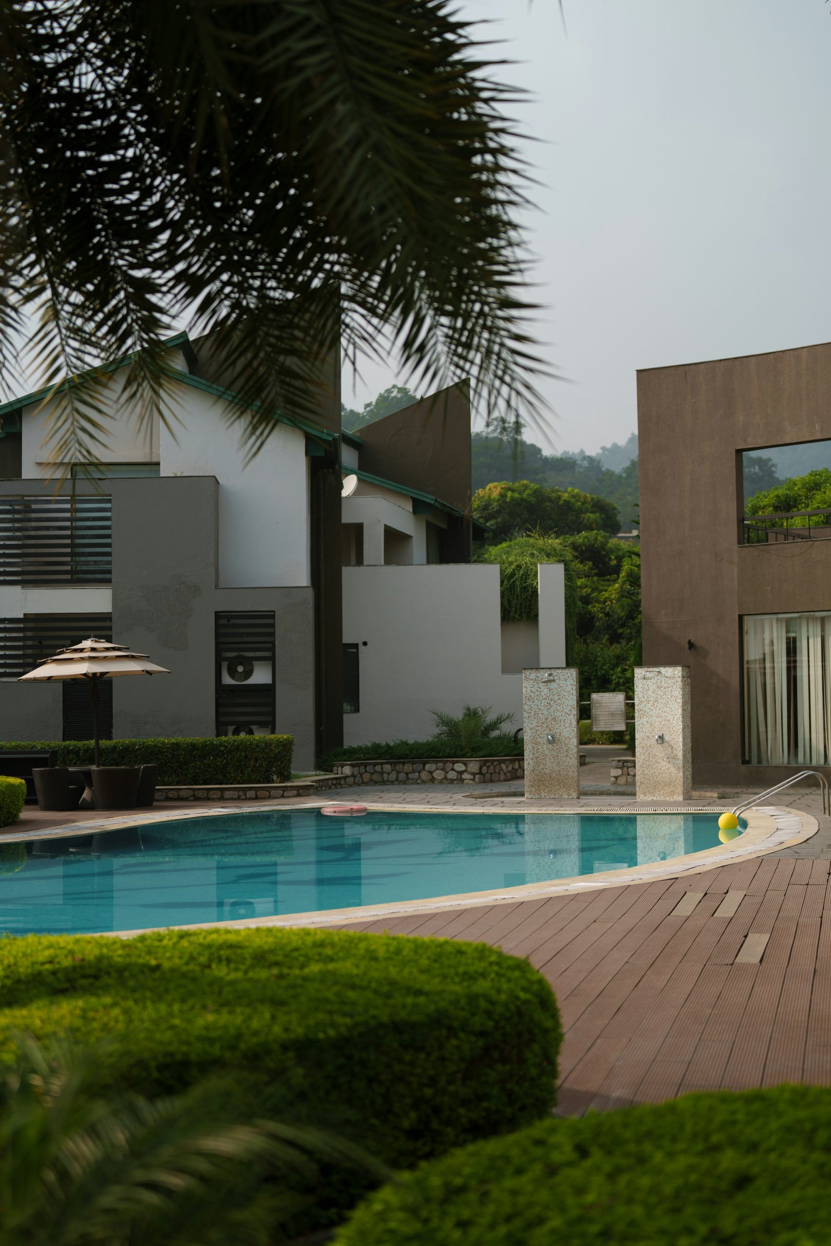 Modern resort with swimming pool and lush green surroundings