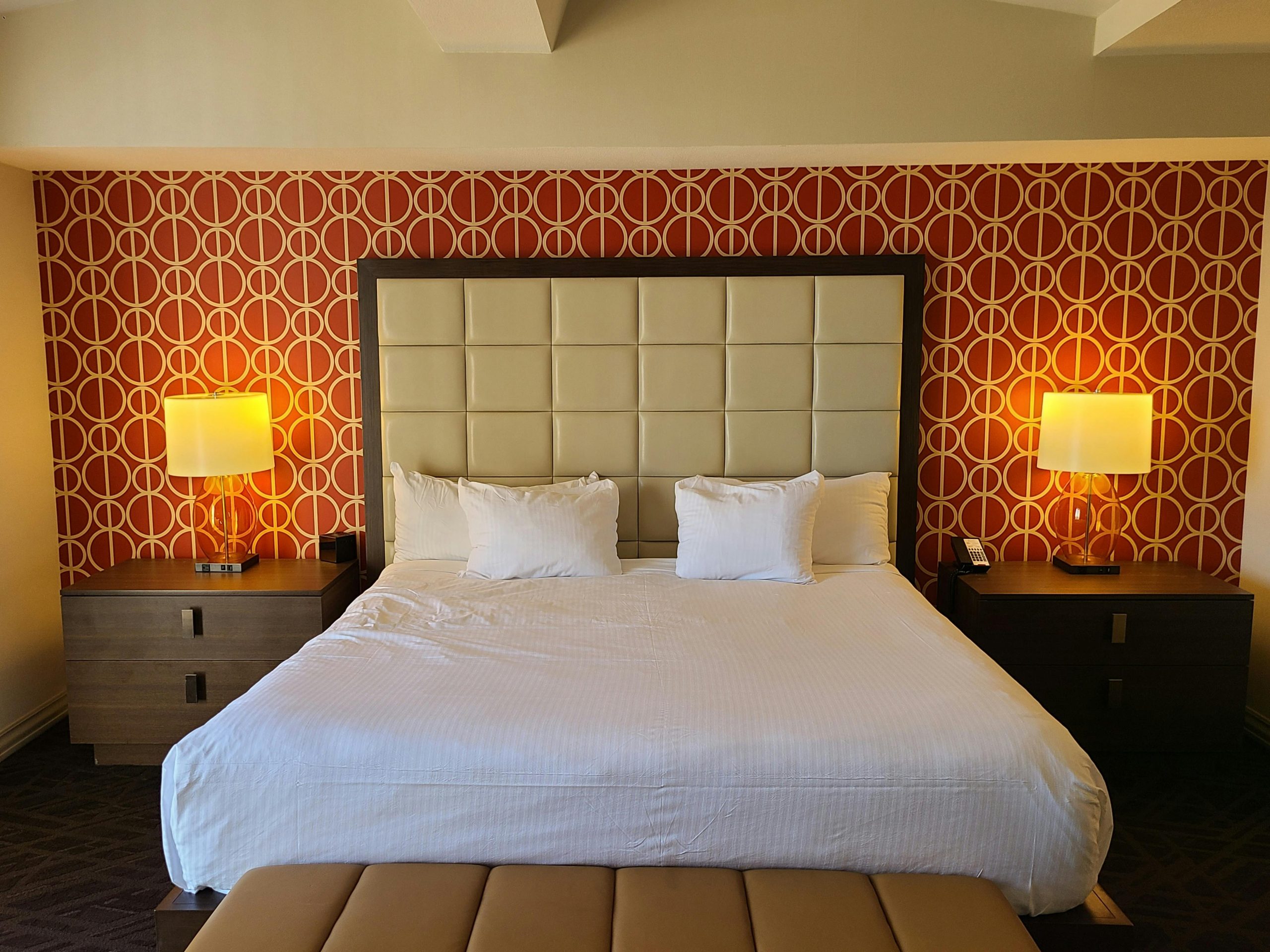 Spacious hotel room in Las Vegas featuring a modern design with a king-size bed and elegant furnishings.
