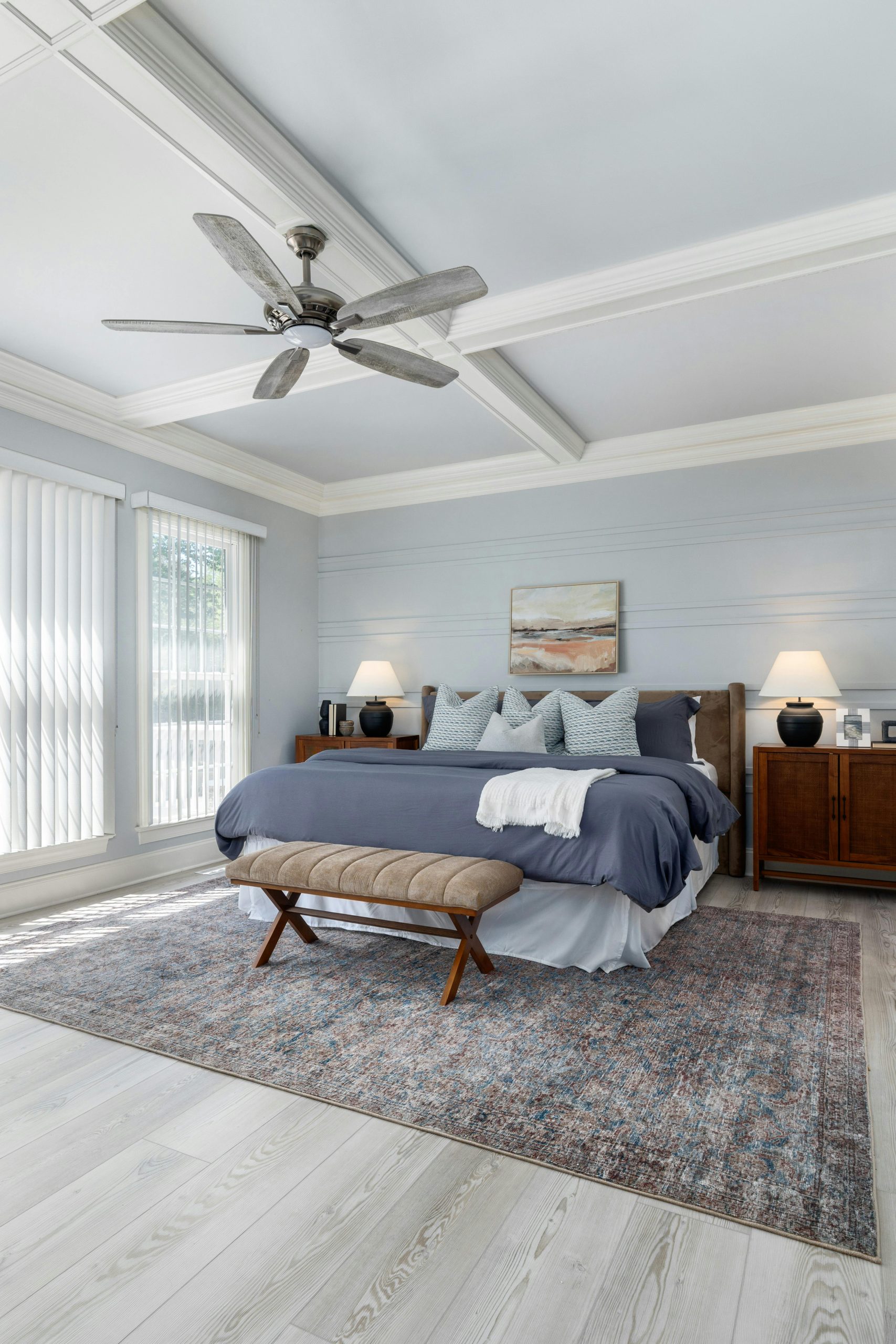 Spacious modern bedroom design featuring a blue color scheme, soft lighting, and elegant furnishings.