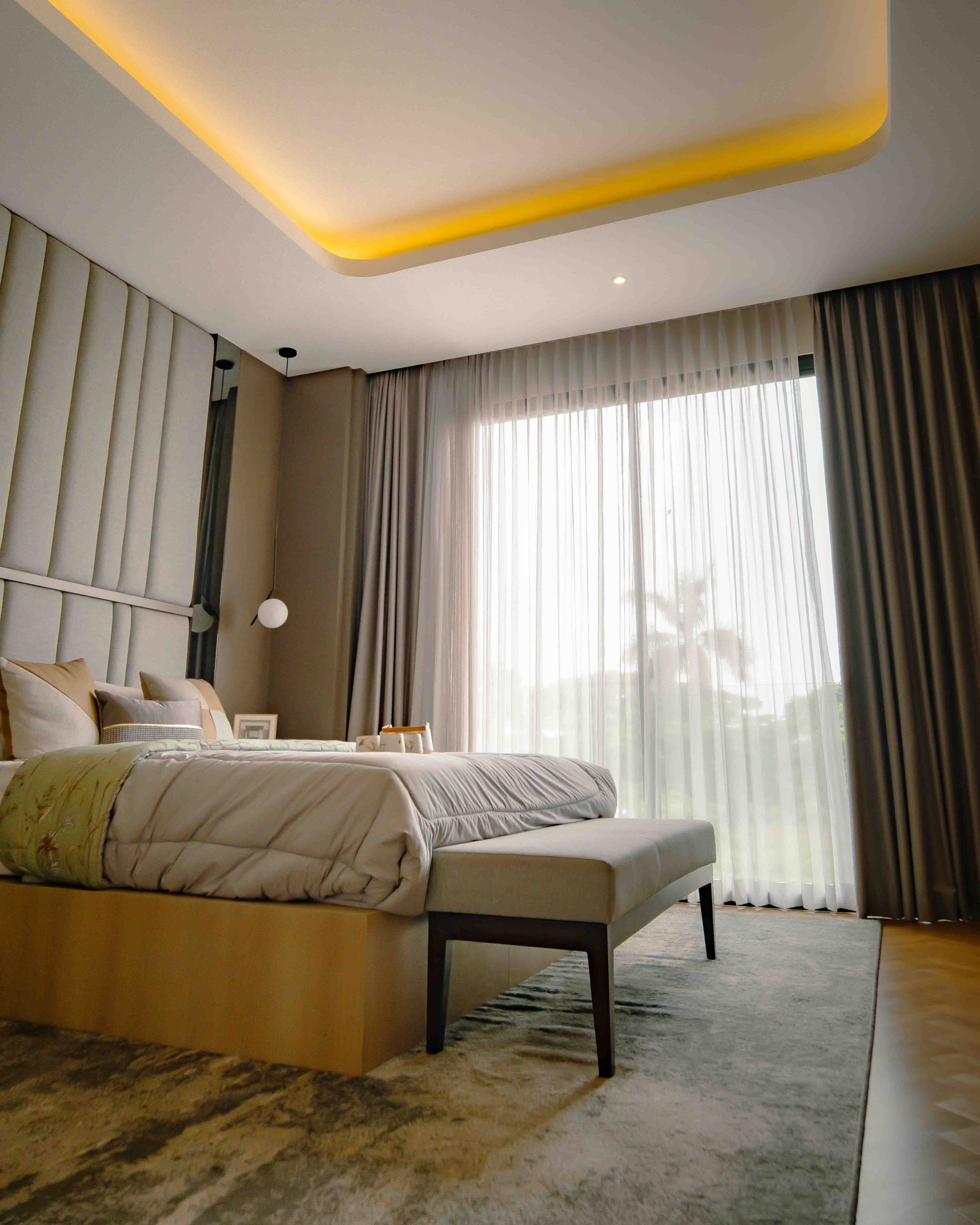 Spacious modern bedroom with elegant decor and natural lighting in Jakarta, Indonesia.