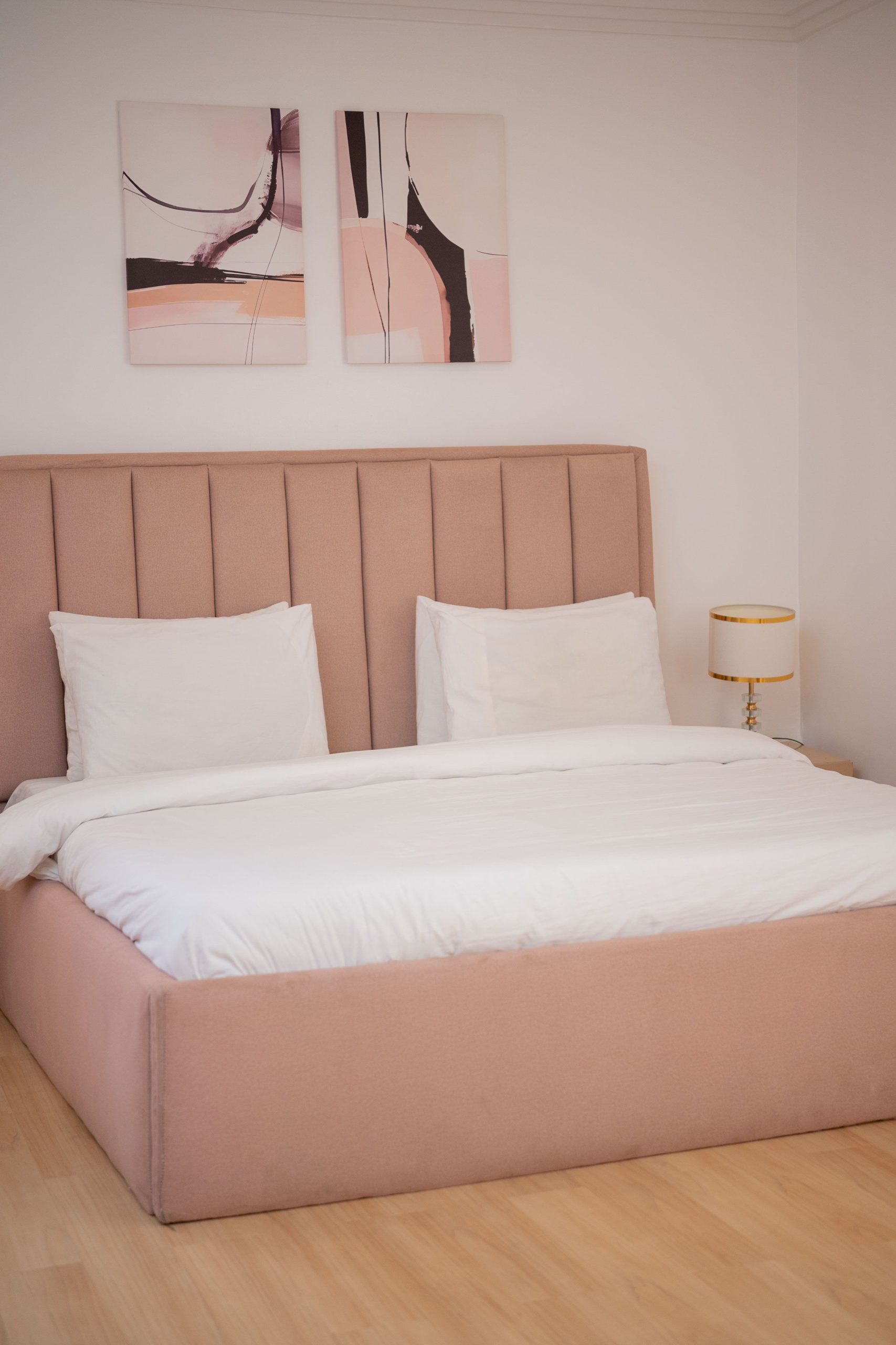 Stylish and serene modern bedroom with a blush upholstered bed, perfect for home inspiration.