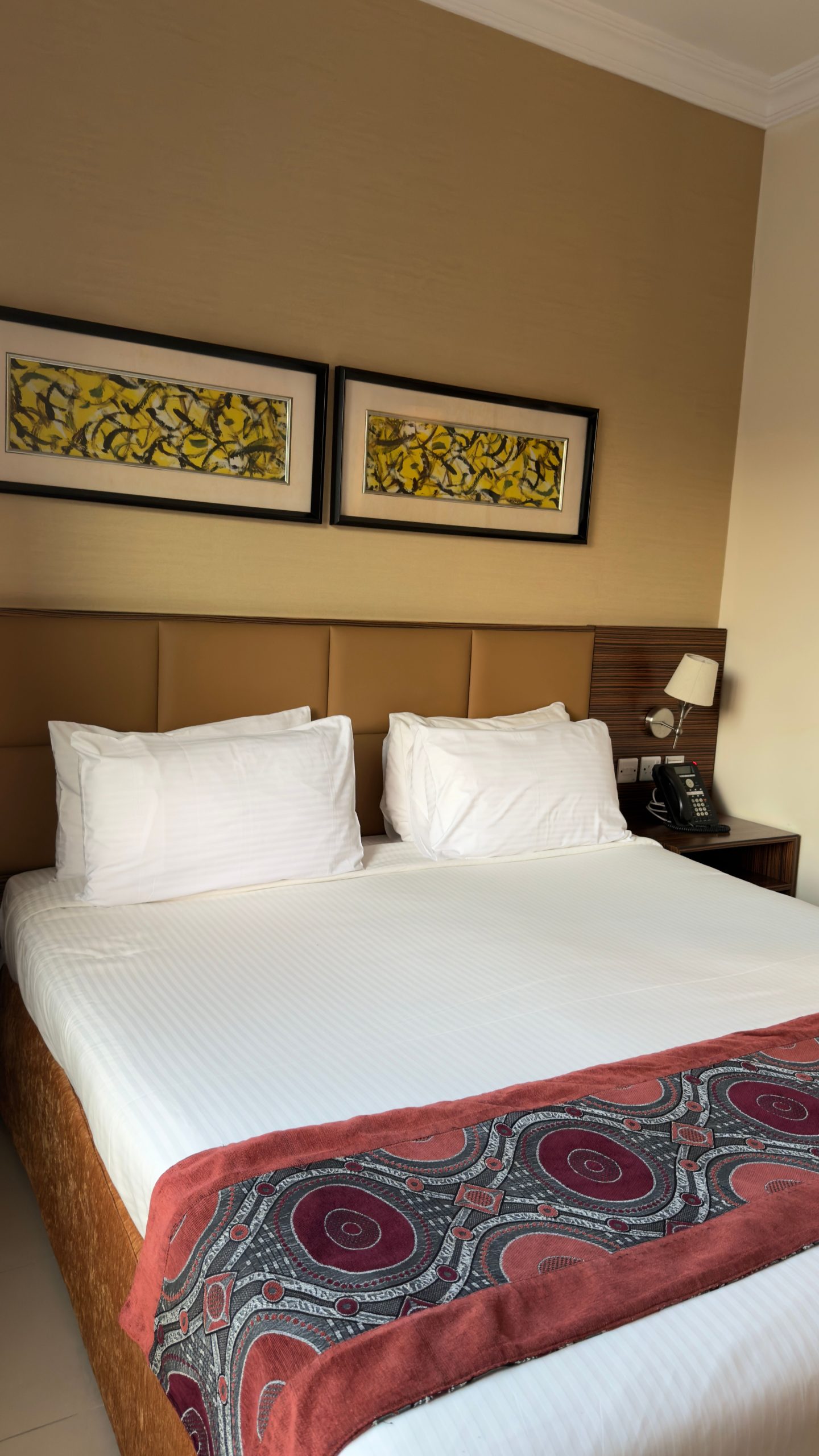 Stylish hotel room with double bed, elegant decor, and artwork.