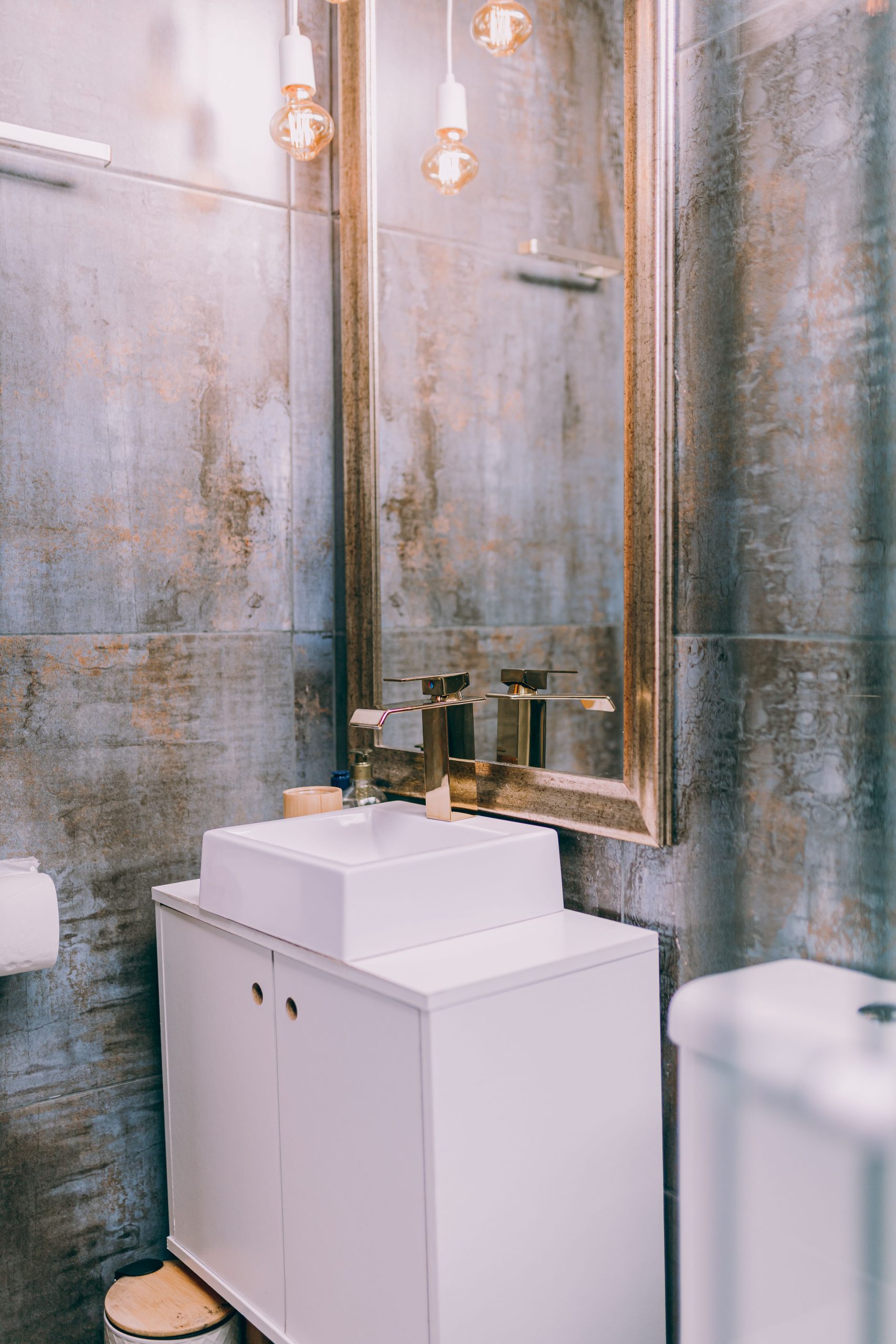 Stylish modern bathroom interior featuring a sleek sink and elegant mirror with warm lighting.