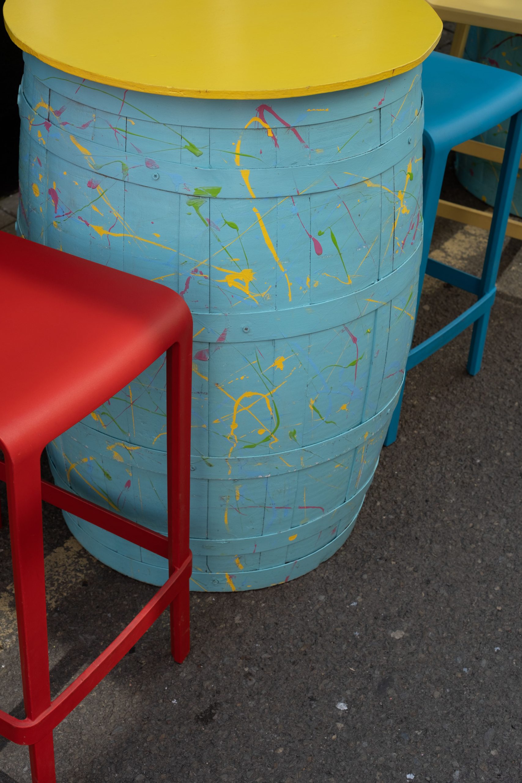 Vibrant outdoor seating with painted barrel table setting in Cork, Ireland.