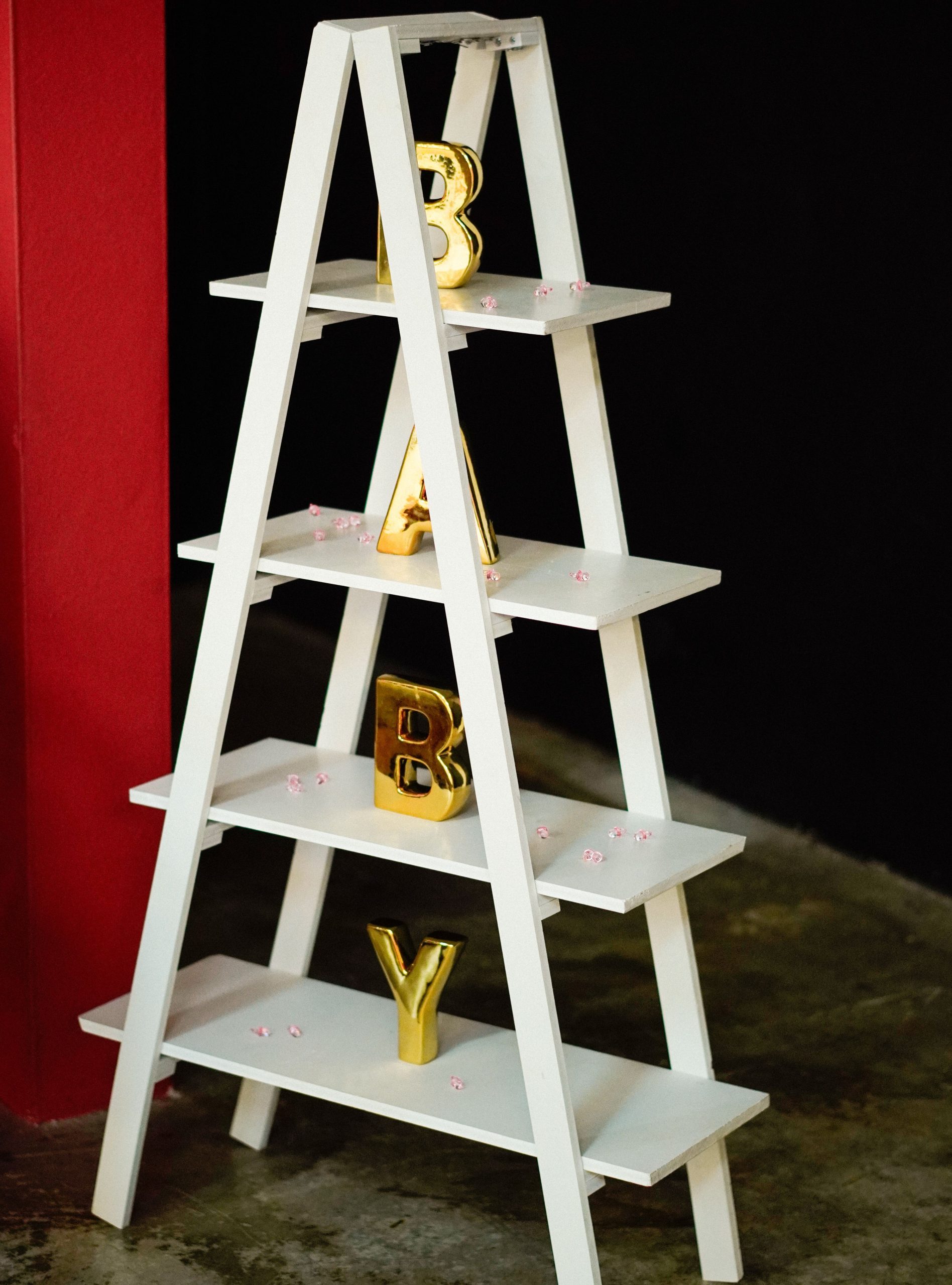 White shelf with gold 'BABY' letters for baby shower decoration.