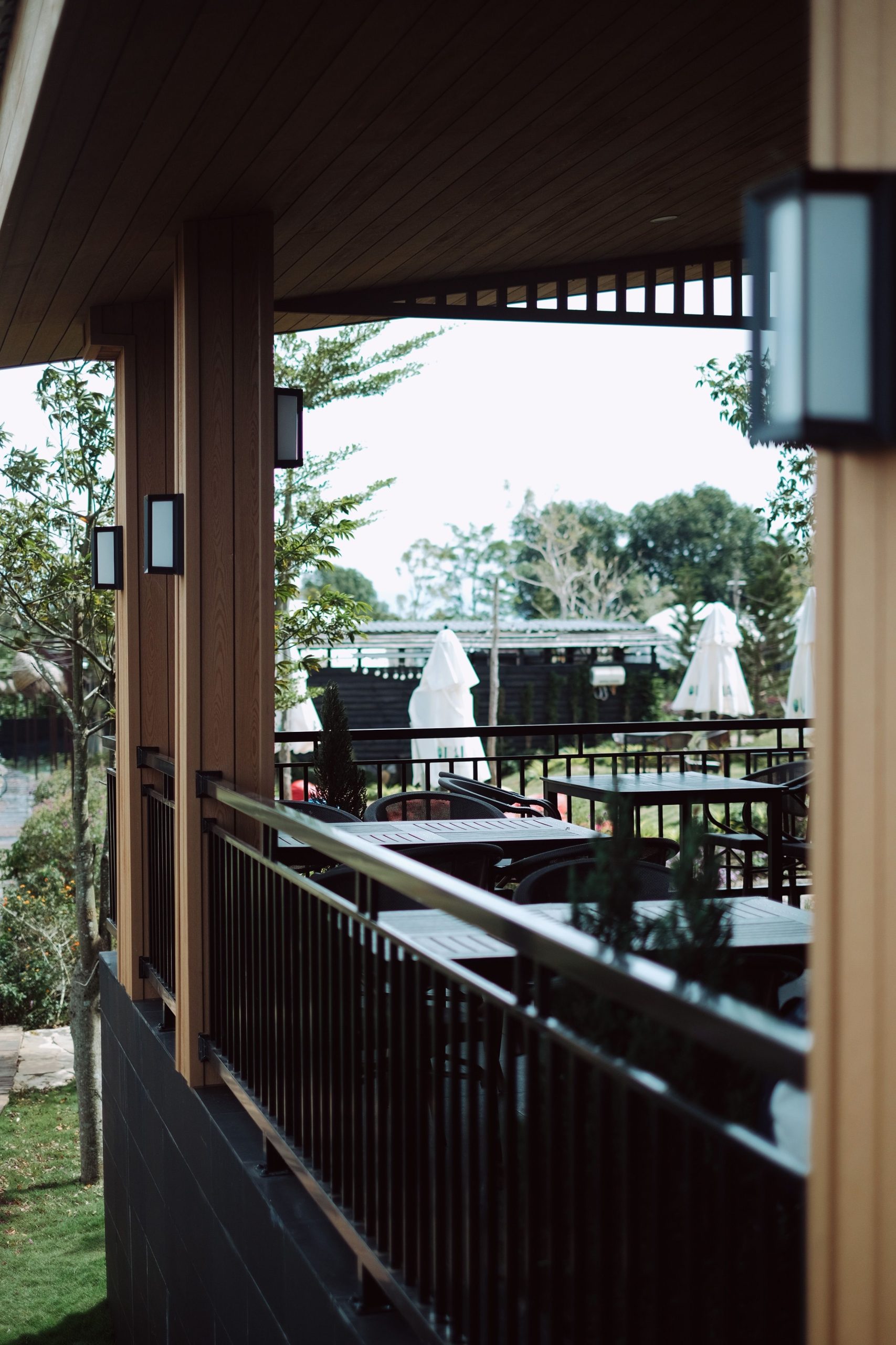 A charming view of an outdoor patio with wooden railings and white umbrellas, perfect for relaxation.