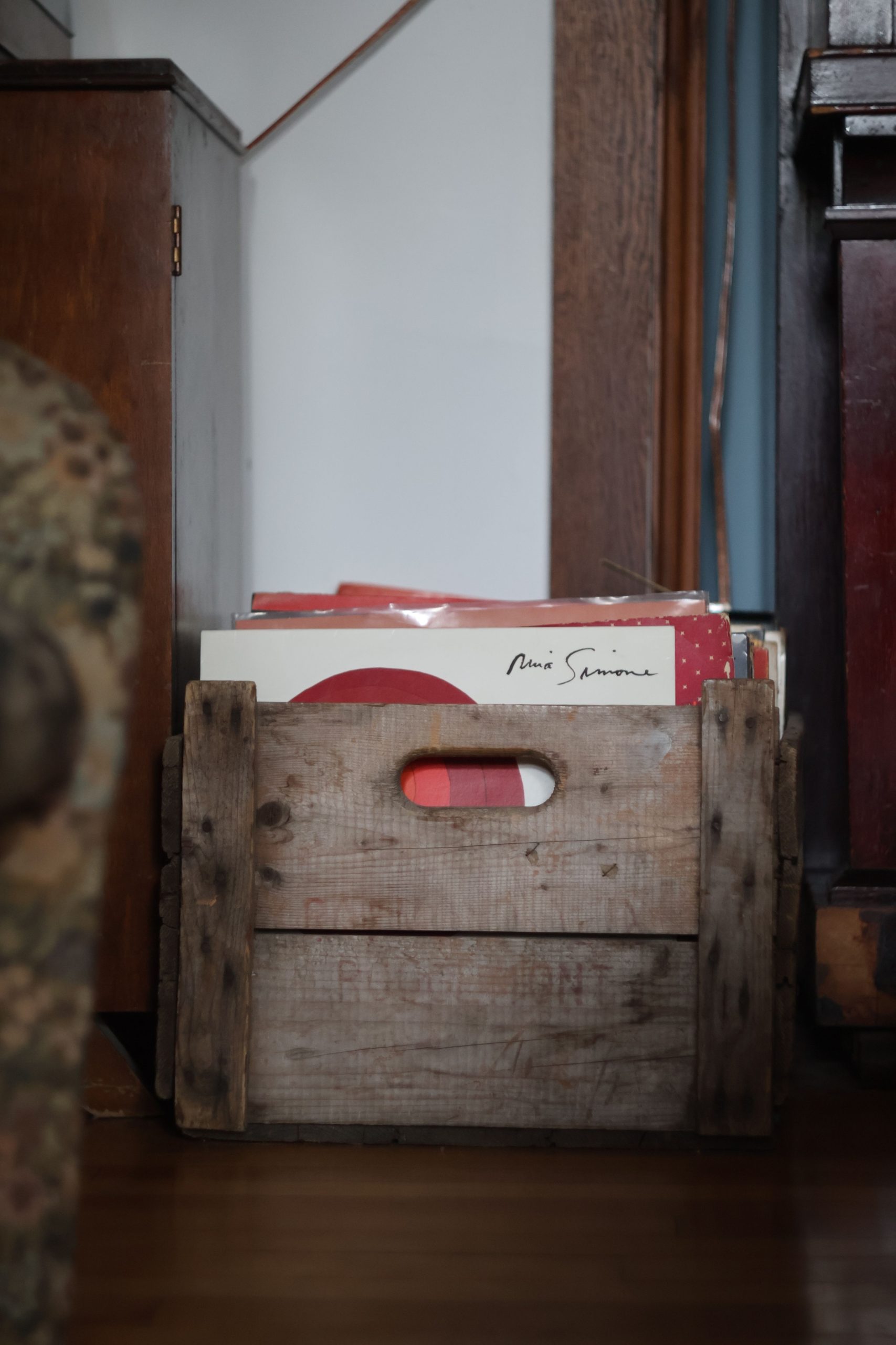 A rustic wooden crate holds vinyl records, adding a vintage touch to a cozy interior in Montreal.