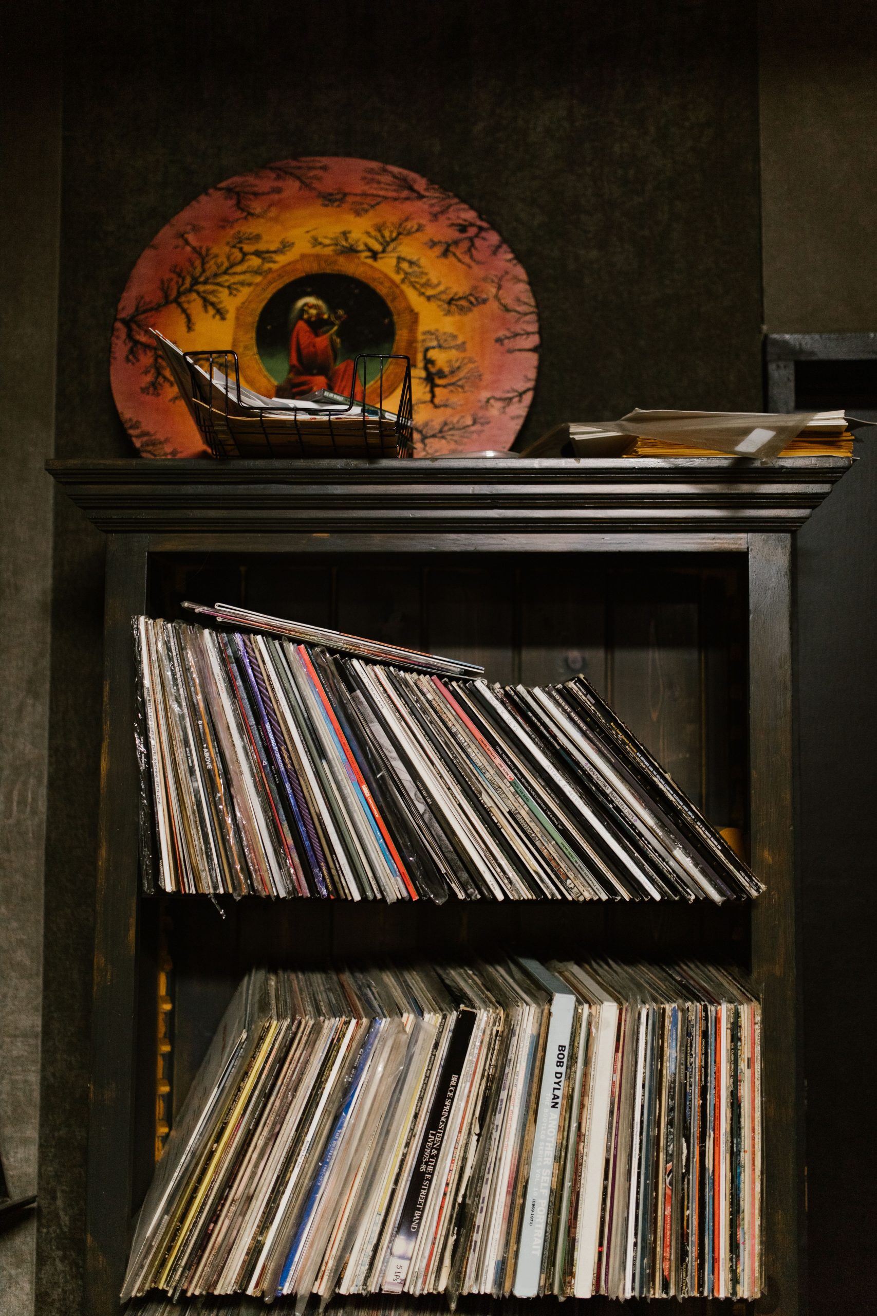 A vintage collection of vinyl records neatly arranged on wooden shelves, perfect for music enthusiasts.