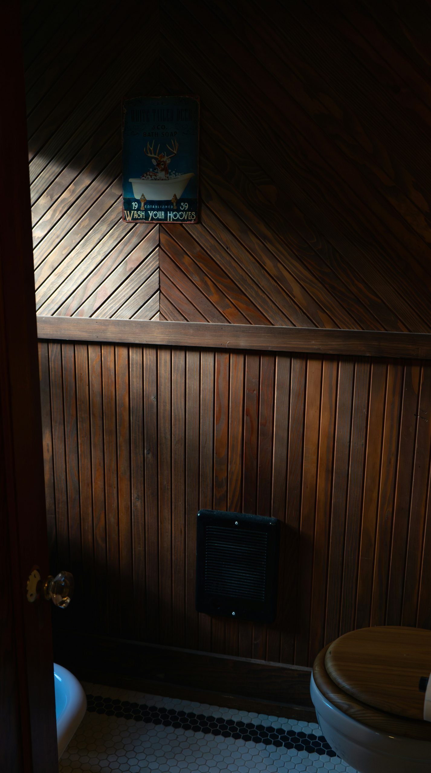 A wooden bathroom with a vintage sign.