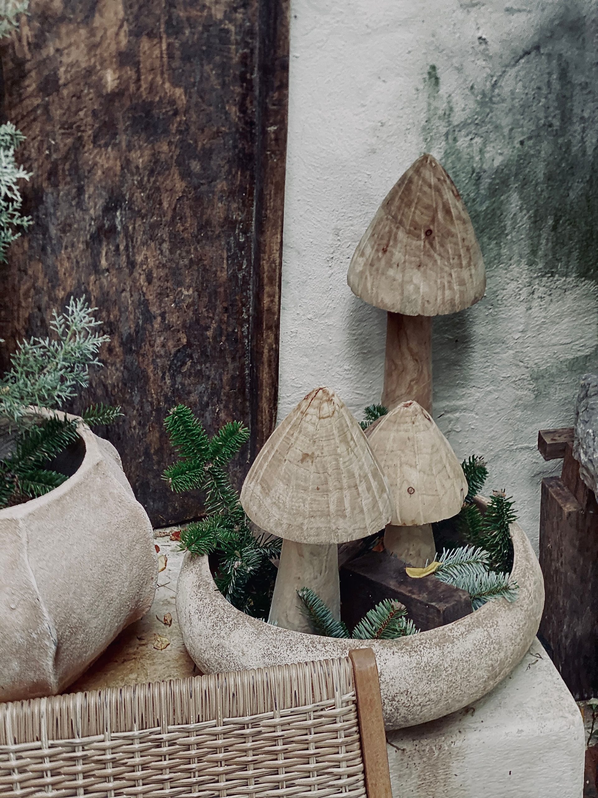 Artistic wooden mushroom decorations placed in a natural rustic garden arrangement.