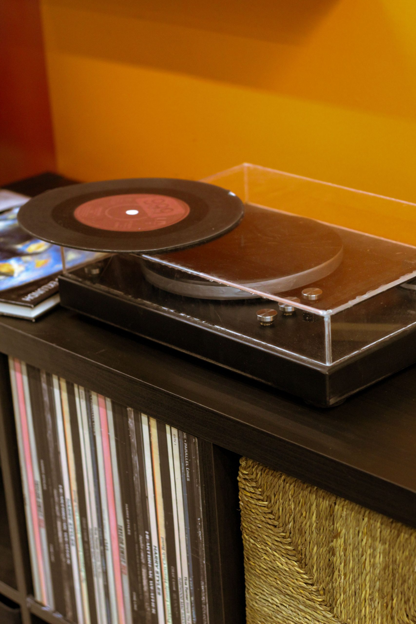 Close-up of a vintage turntable with vinyl records in a warm, nostalgic setting.