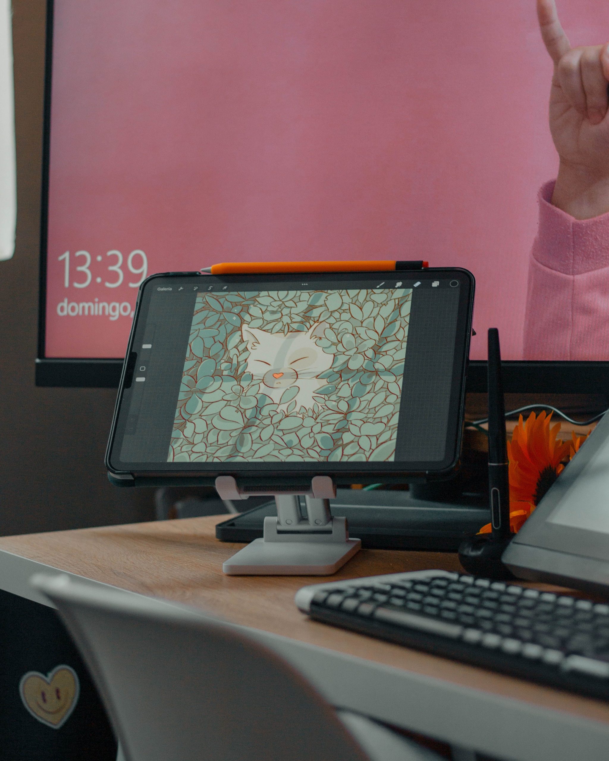 Cozy workspace featuring a tablet, keyboard, and vibrant digital art displayed on screen.