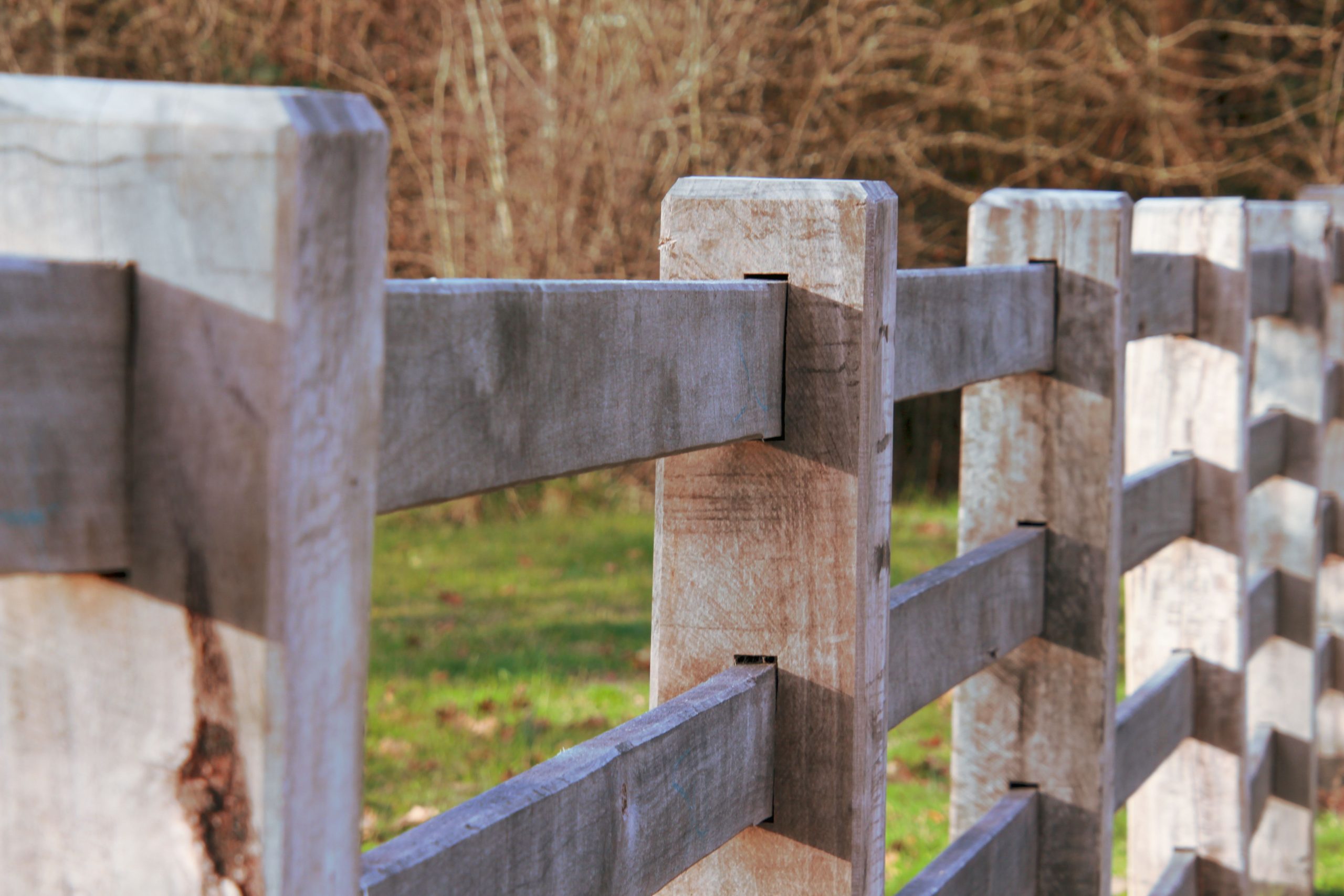 Detailed shot of a wooden fence with a natural background, capturing texture and depth.
