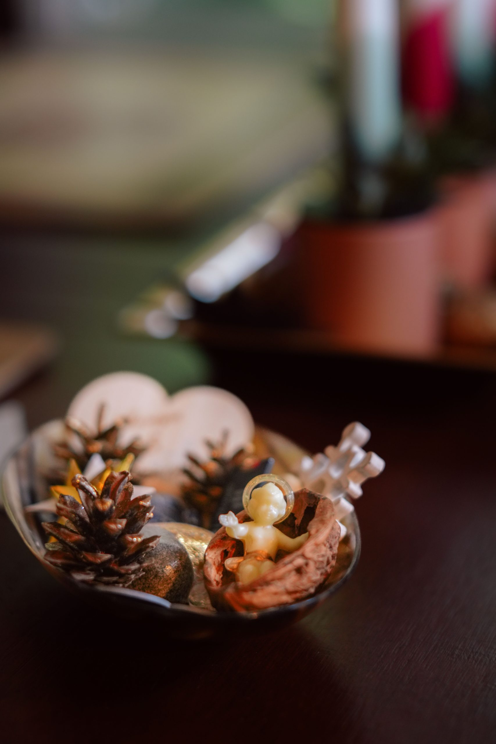 Elegant bowl with pinecones and Christmas figurines, perfect for holiday decor.