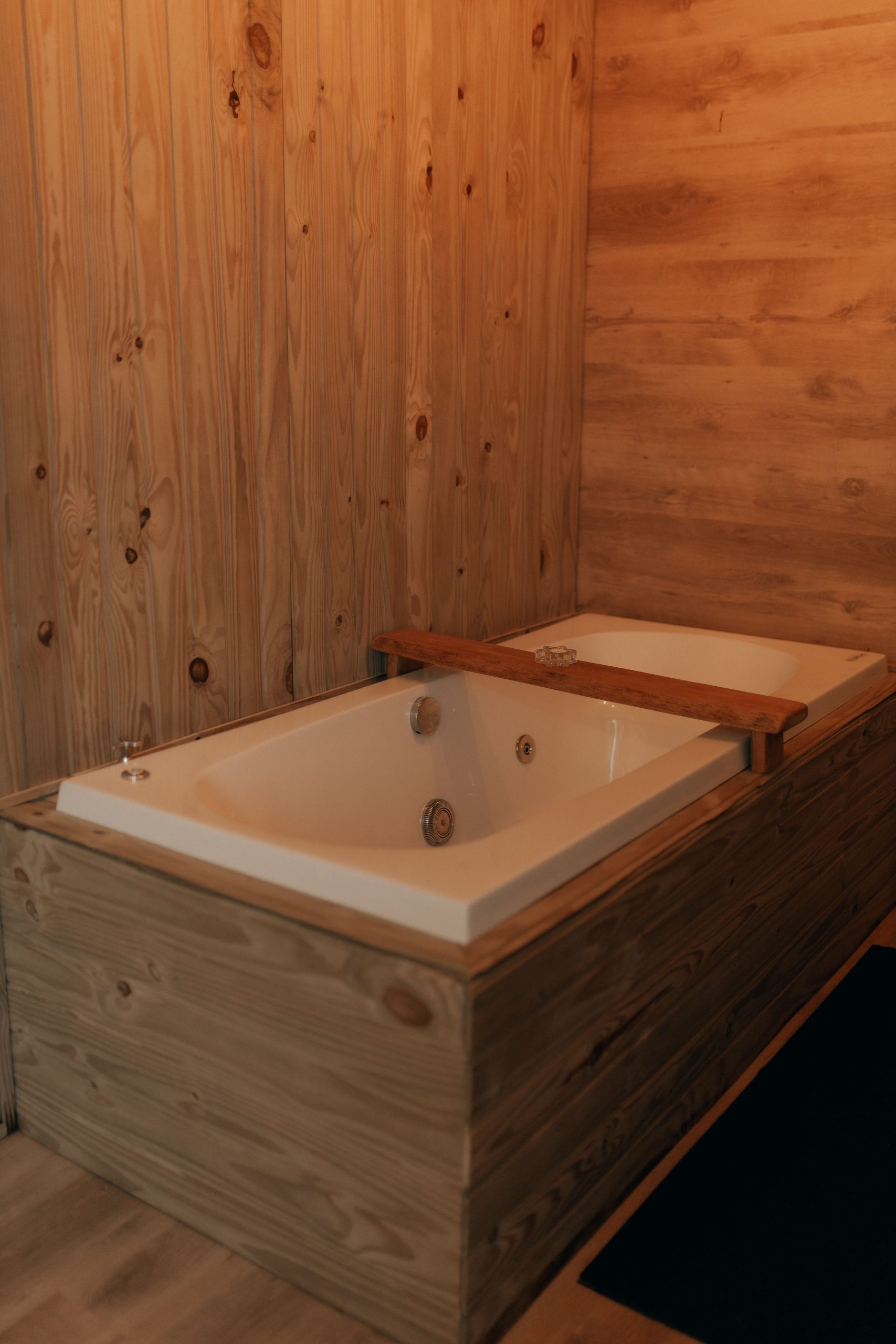 Elegant wooden bathtub setup in a cozy interior, perfect for relaxation and comfort.