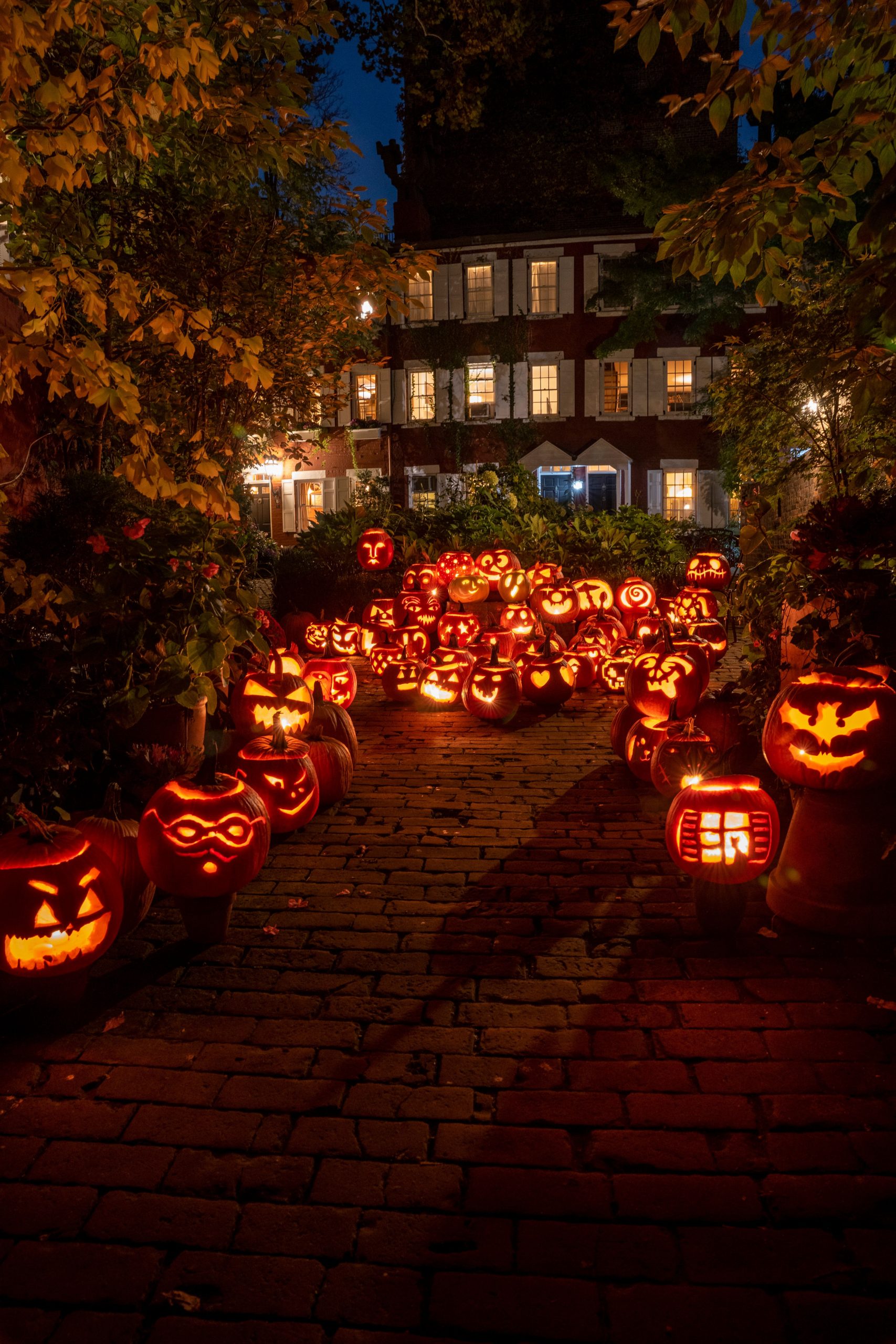 Halloween night with glowing jack o' lanterns on a New York City street.