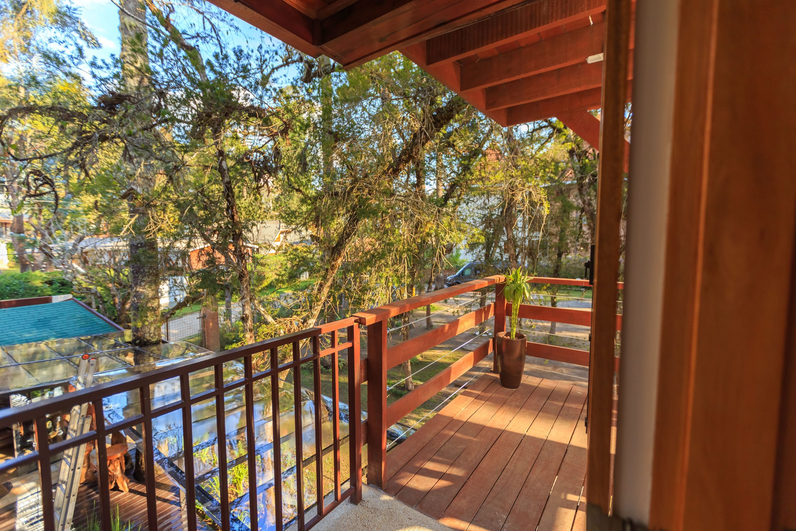 Inviting wooden balcony with railing, overlooking a lush garden. Perfect for relaxation.