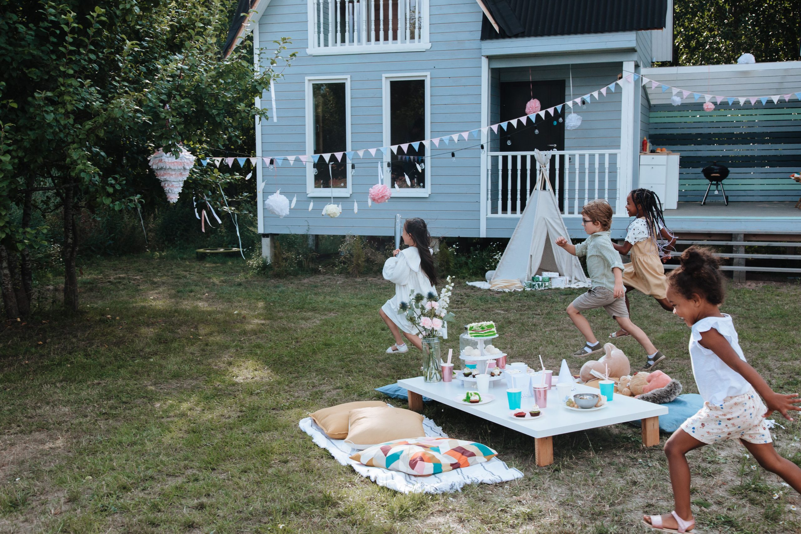 Kids enjoy a lively birthday party outdoors with a piñata and decorations.