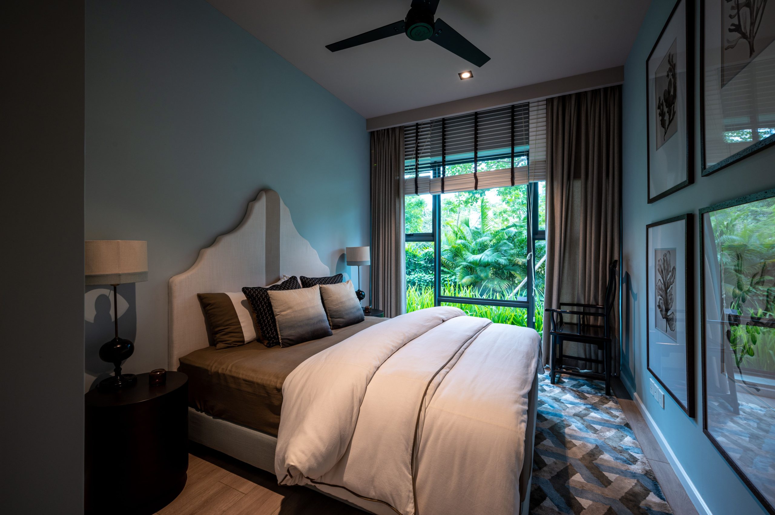 Modern bedroom interior with natural light and scenic garden view through large window.