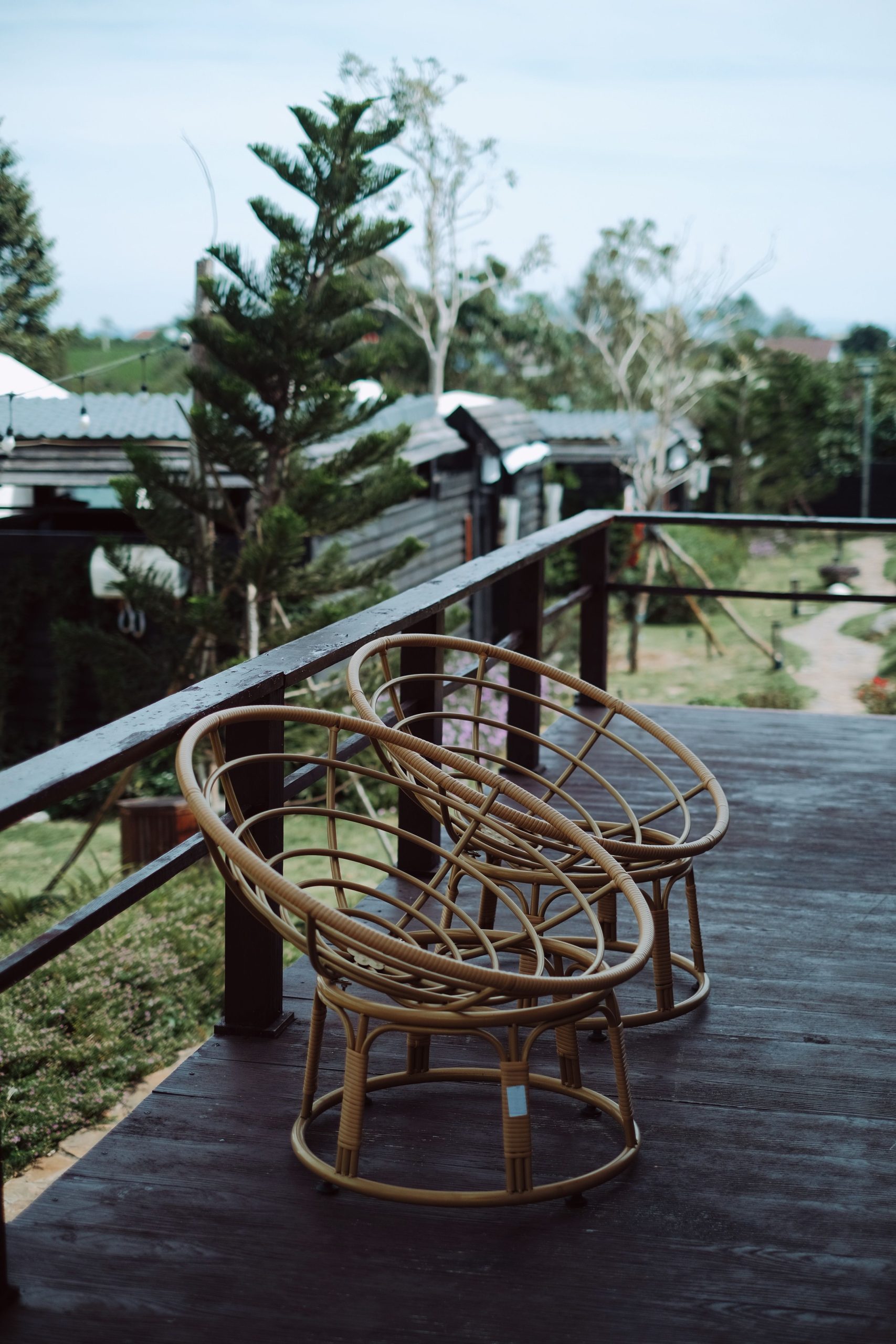 Serene outdoor deck with bamboo chairs overlooking lush garden.