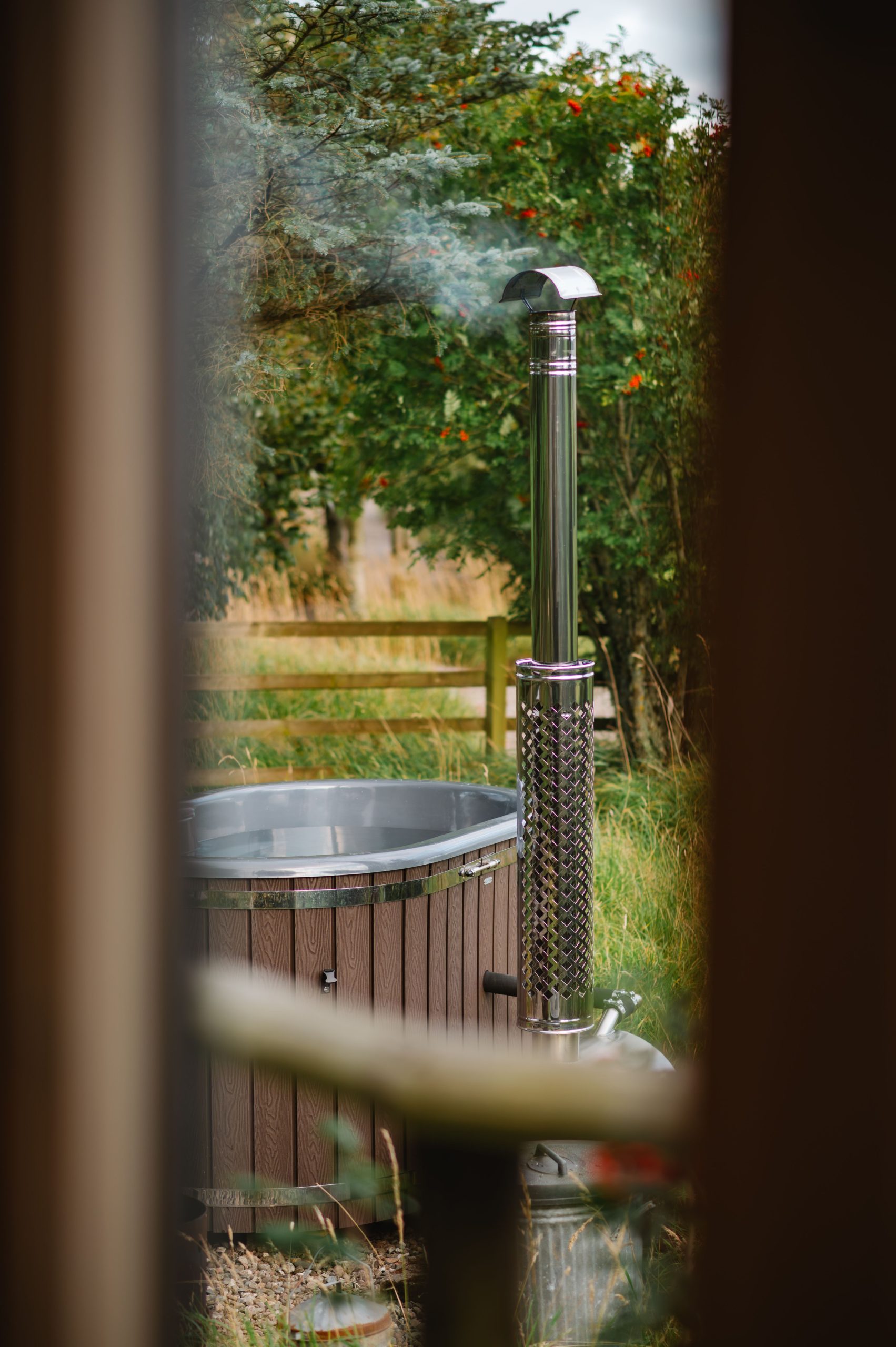 Serene view of a wood-fired hot tub surrounded by nature in Dunblane, Scotland.