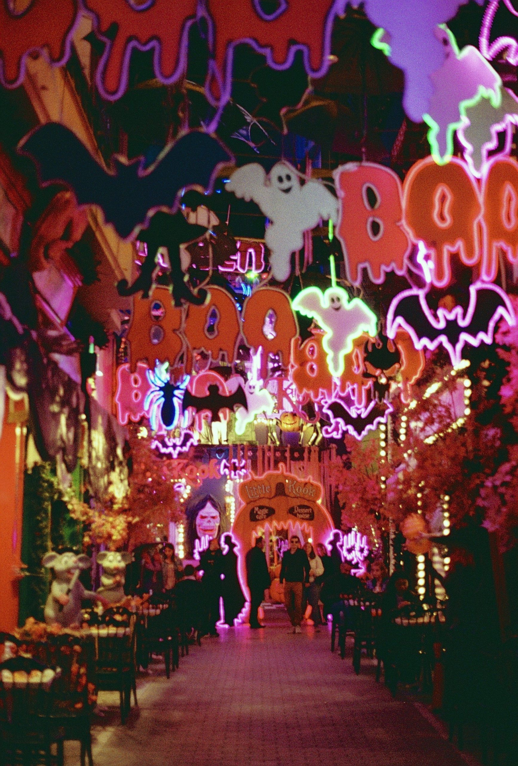 Vibrant Halloween-themed street decorations in Athens featuring illuminated ghosts and bats.