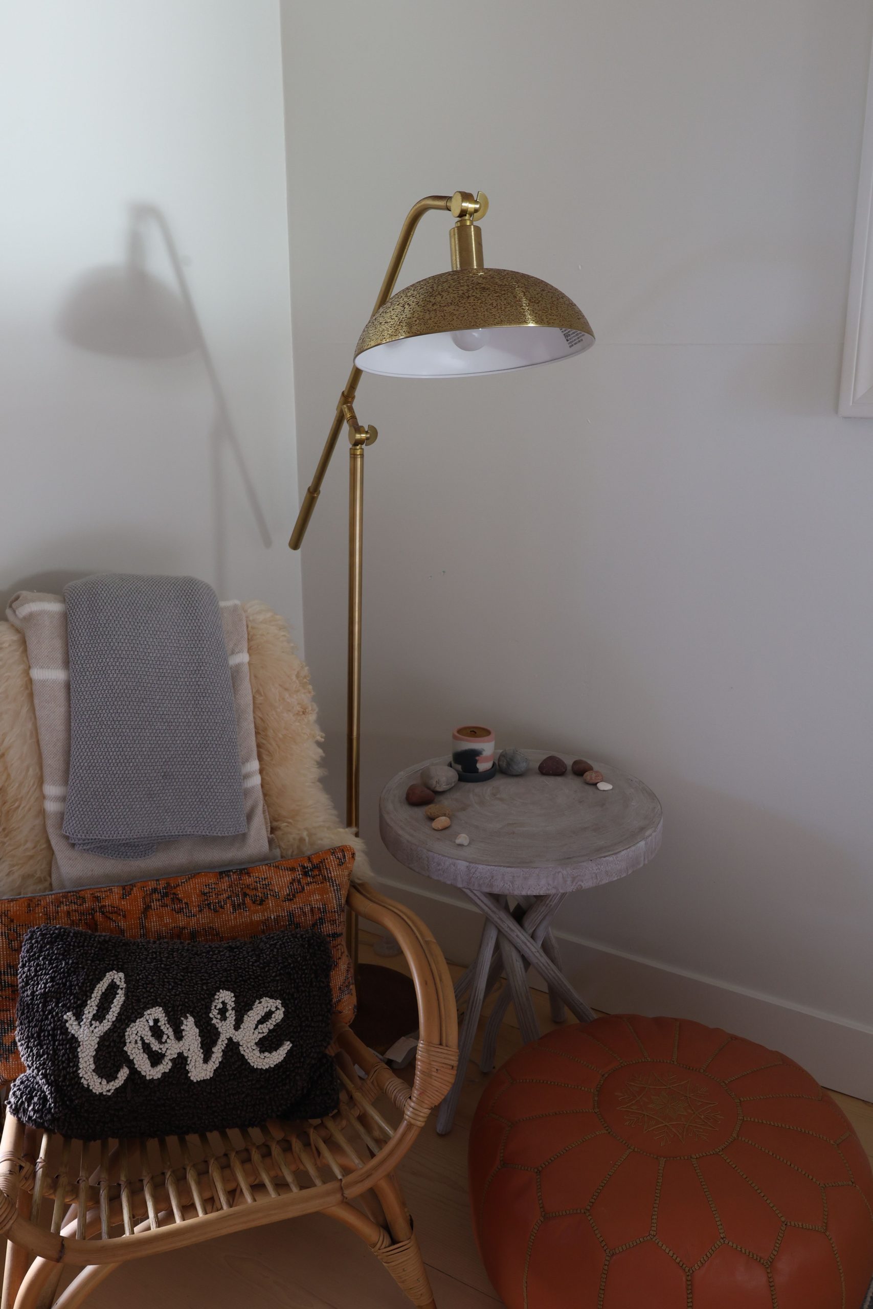 Warm and inviting reading nook with a woven chair, plush pillows, and ambient lighting.