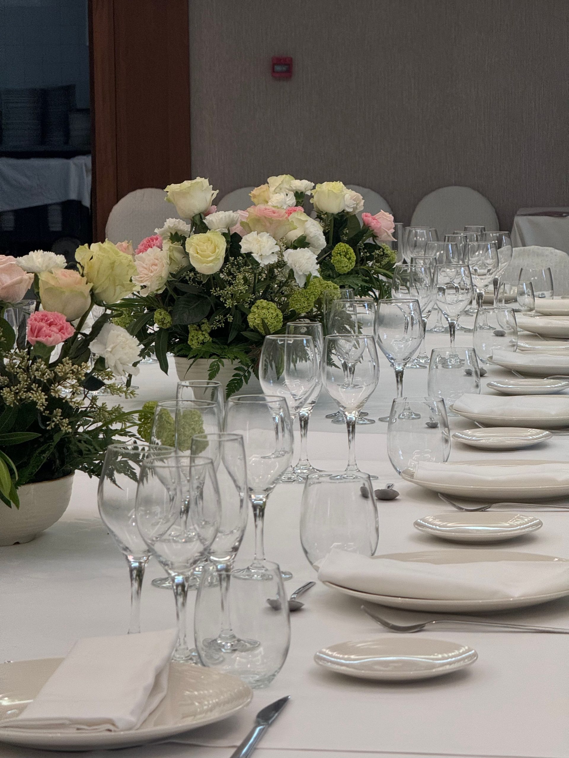 A beautifully arranged dining table with glassware and floral centerpieces in an elegant setting.