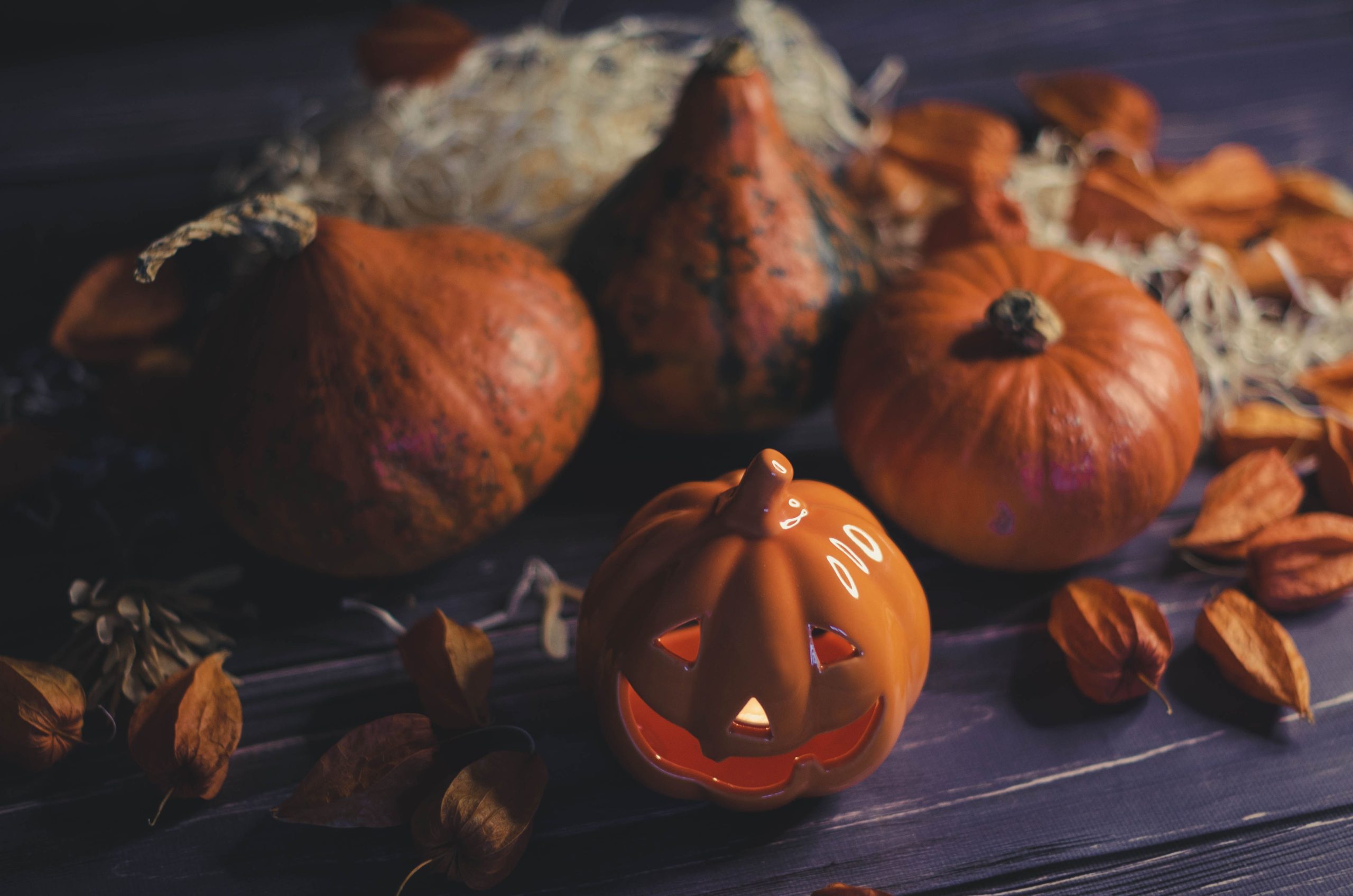 A cozy Halloween scene with carved pumpkins and autumn leaves, perfect for seasonal decoration.