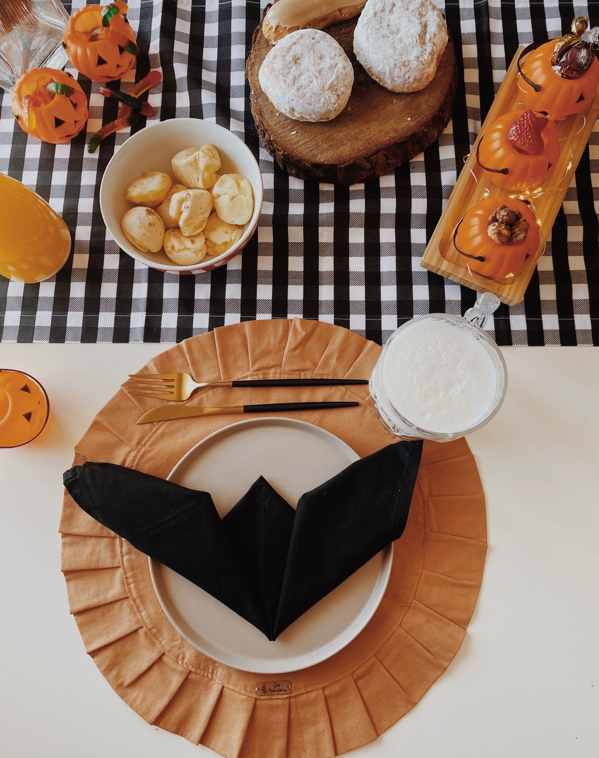A Halloween-themed breakfast table with pumpkin decor and pastries in São Paulo.