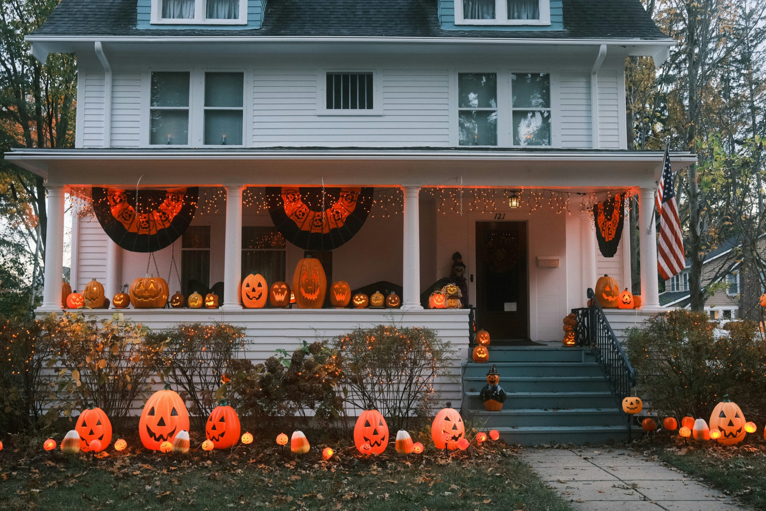 A house decorated for halloween with pumpkins and lights