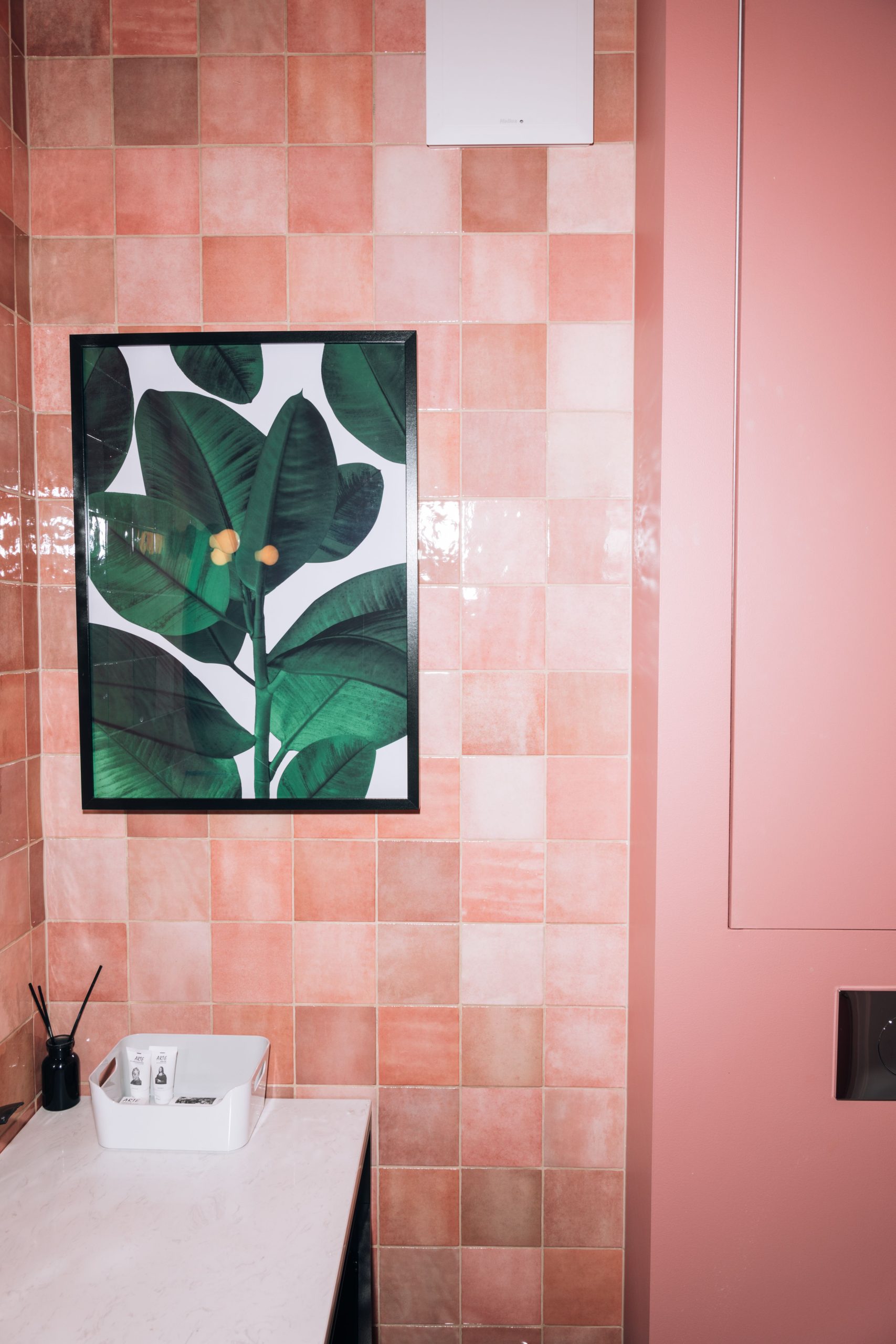 A luxury pink bathroom featuring a botanical painting and modern decor.