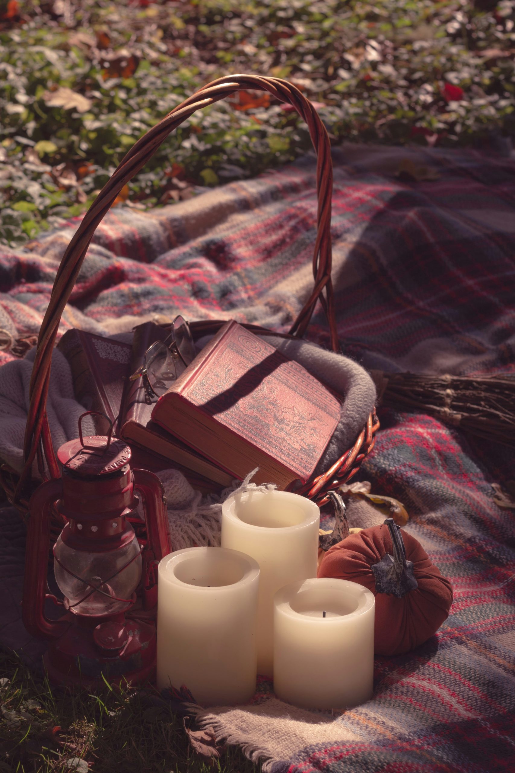 a picnic blanket with candles and a book on it