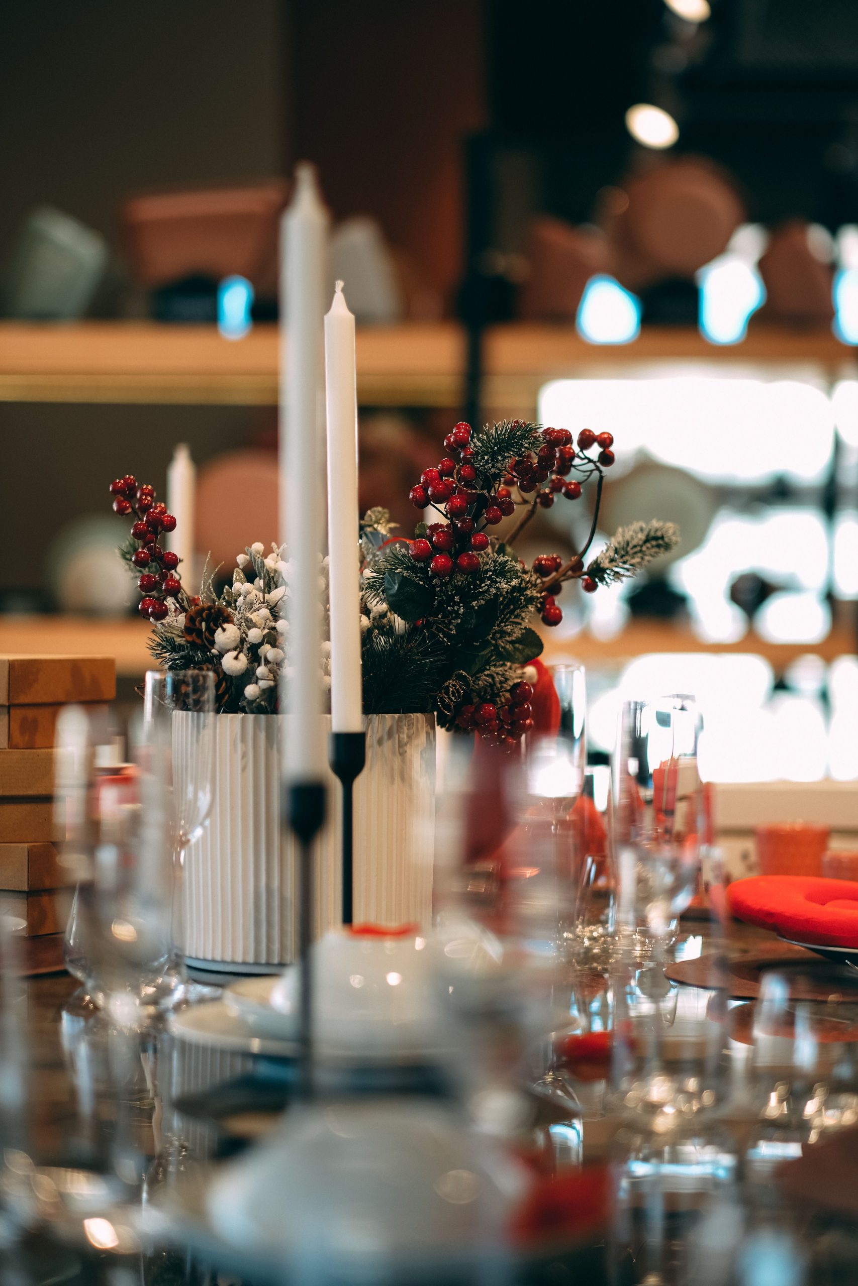 A refined table arrangement featuring candles and festive floral centerpiece, perfect for celebrations.