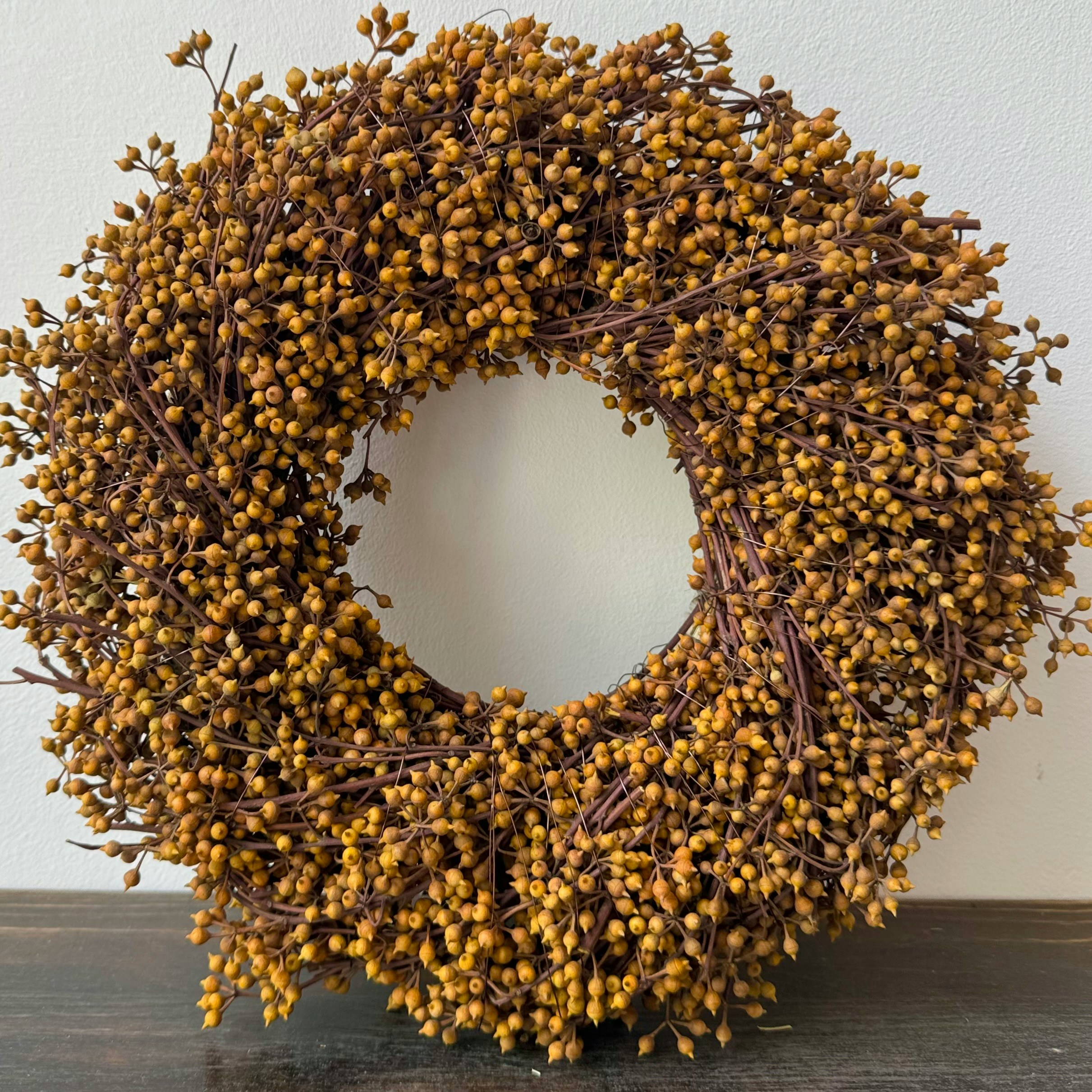 A rustic wreath made of small brown berries