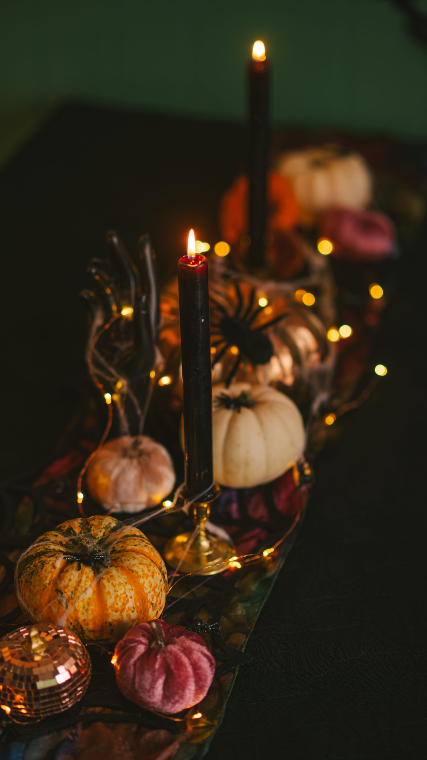 A sophisticated fall-themed table setting featuring pumpkins, candles, and warm lighting.