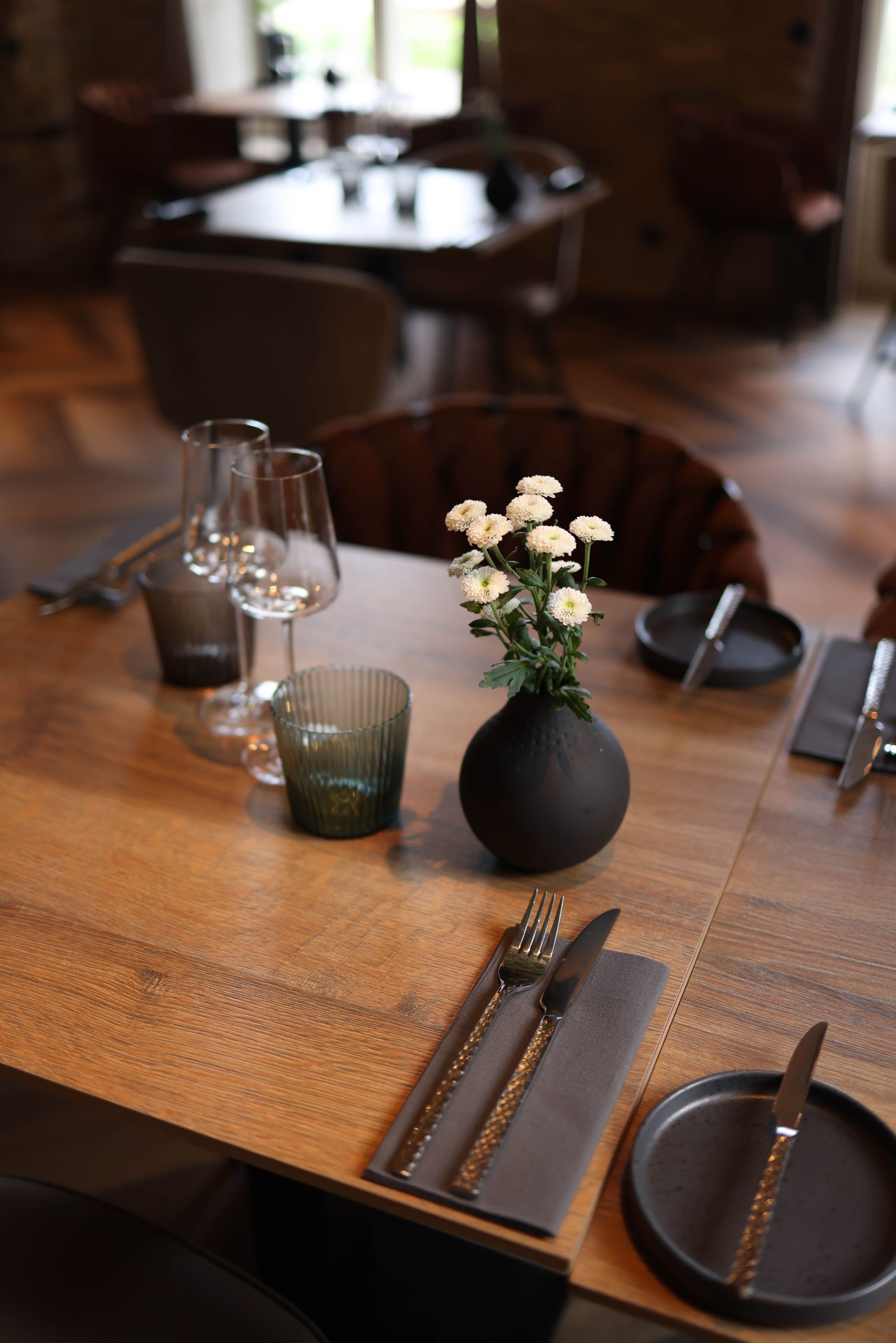 A sophisticated restaurant table setting featuring elegant cutlery and floral decoration, perfect for fine dining.