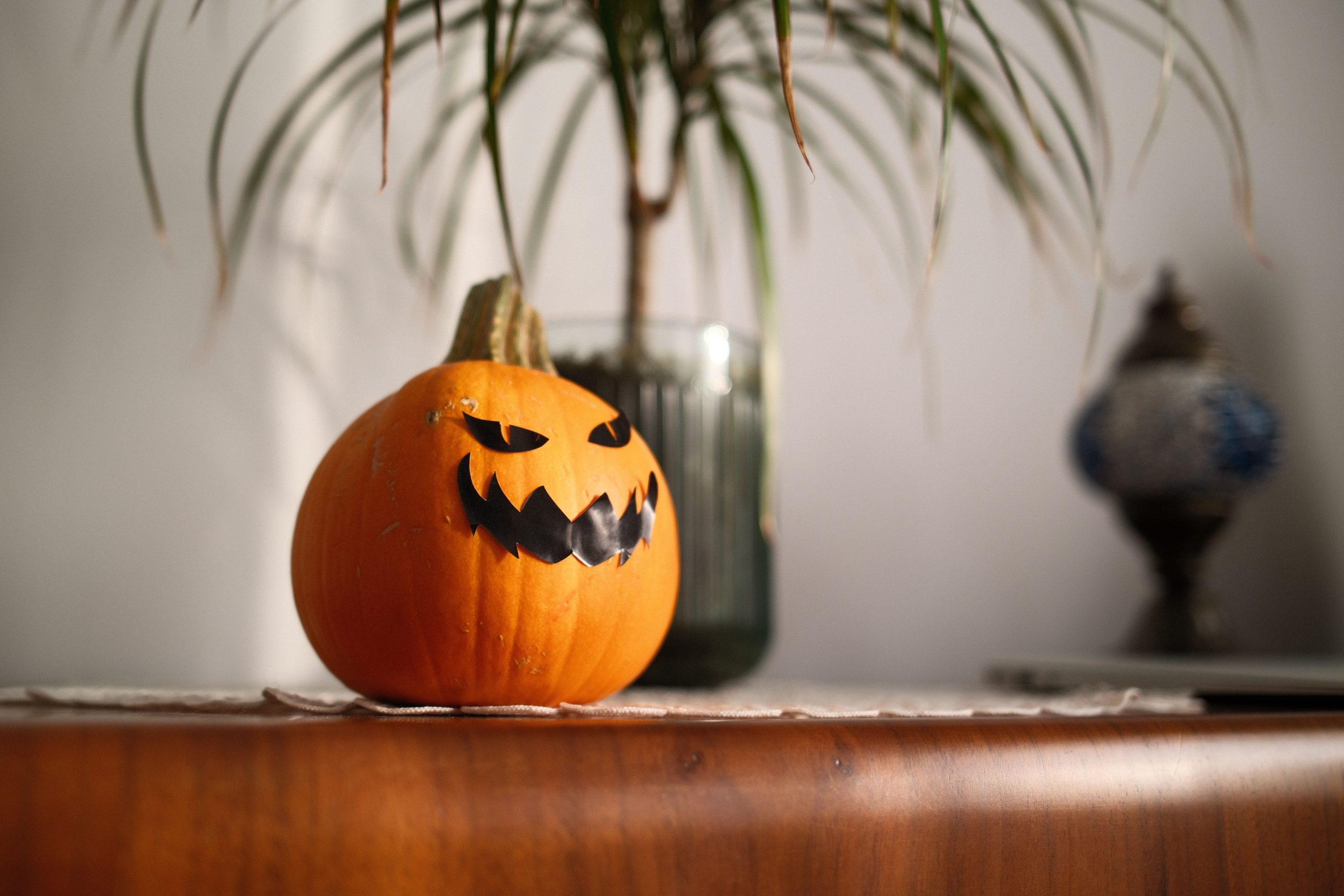 A spooky jack-o'-lantern decorates an indoor setting for Halloween.
