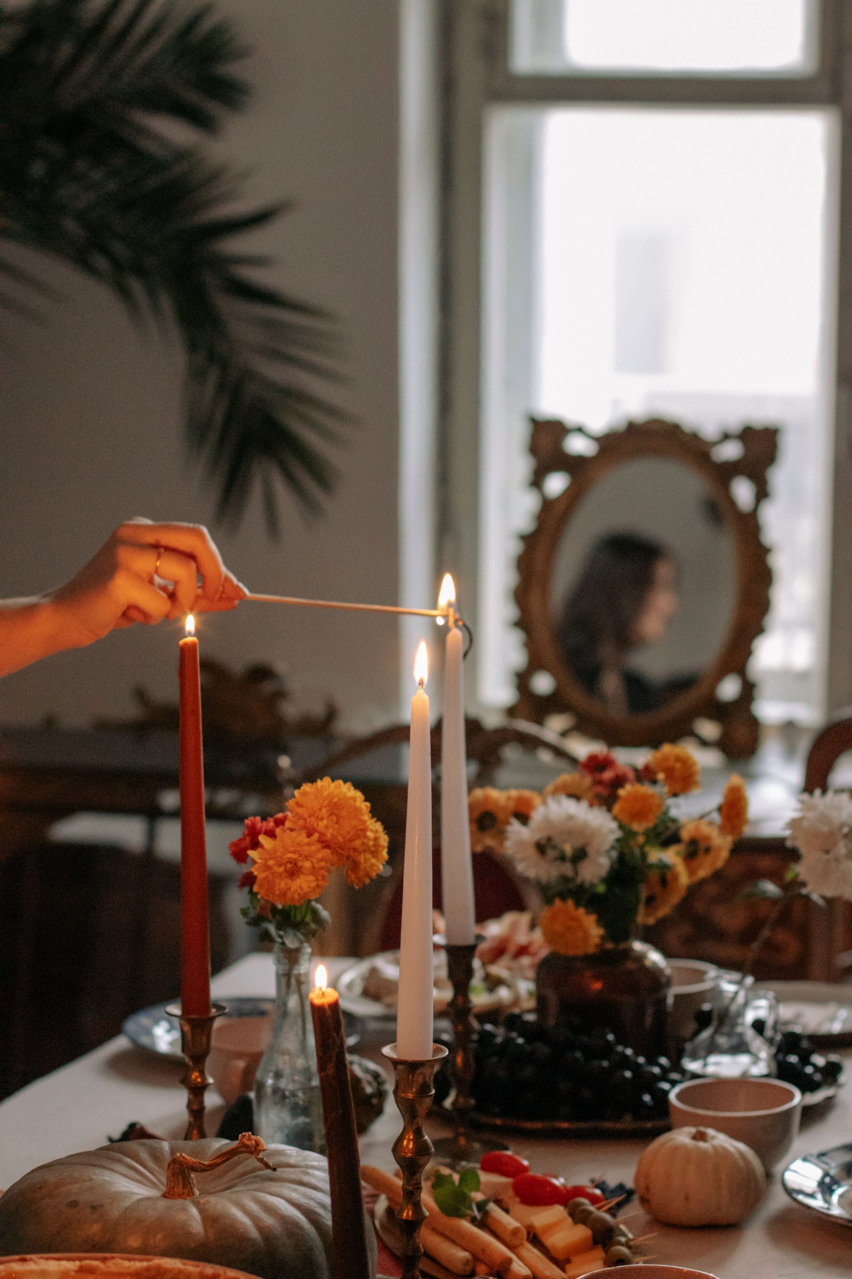 A warm and inviting autumn table setting adorned with candles, flowers, and seasonal decor, perfect for festive gatherings.