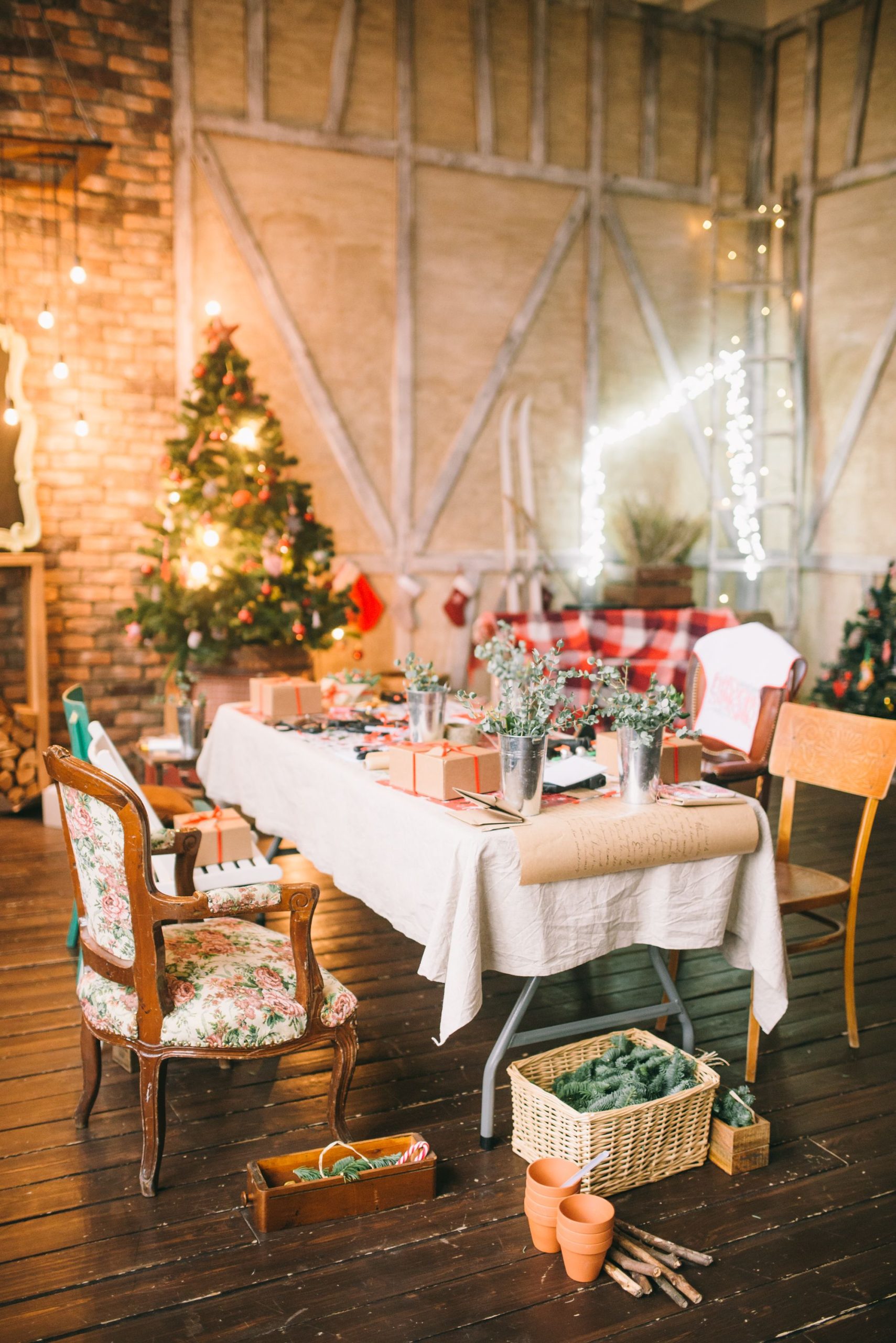 A warmly lit Christmas dining room with a decorated tree and festive table settings.