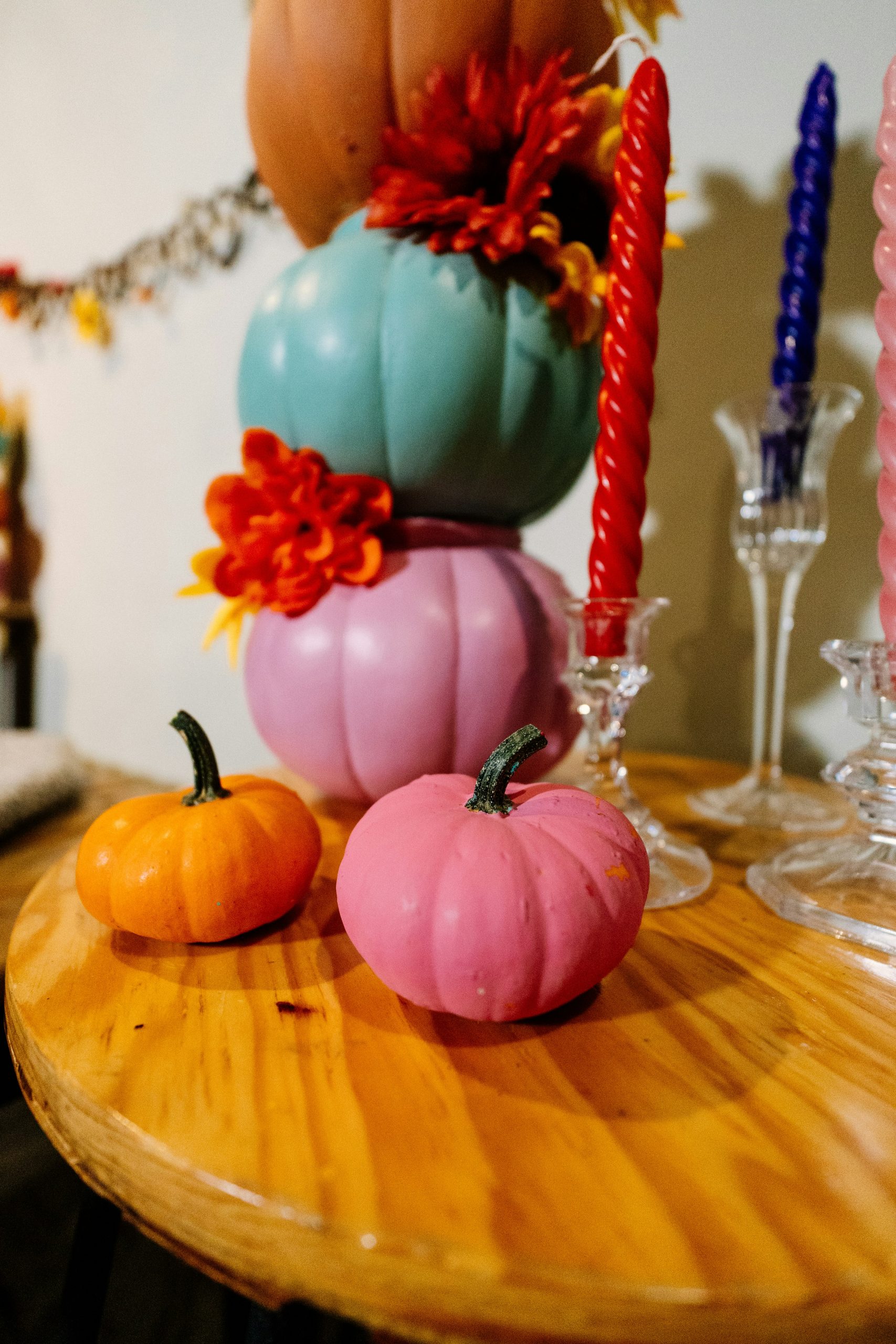 a wooden table topped with lots of different colored pumpkins
