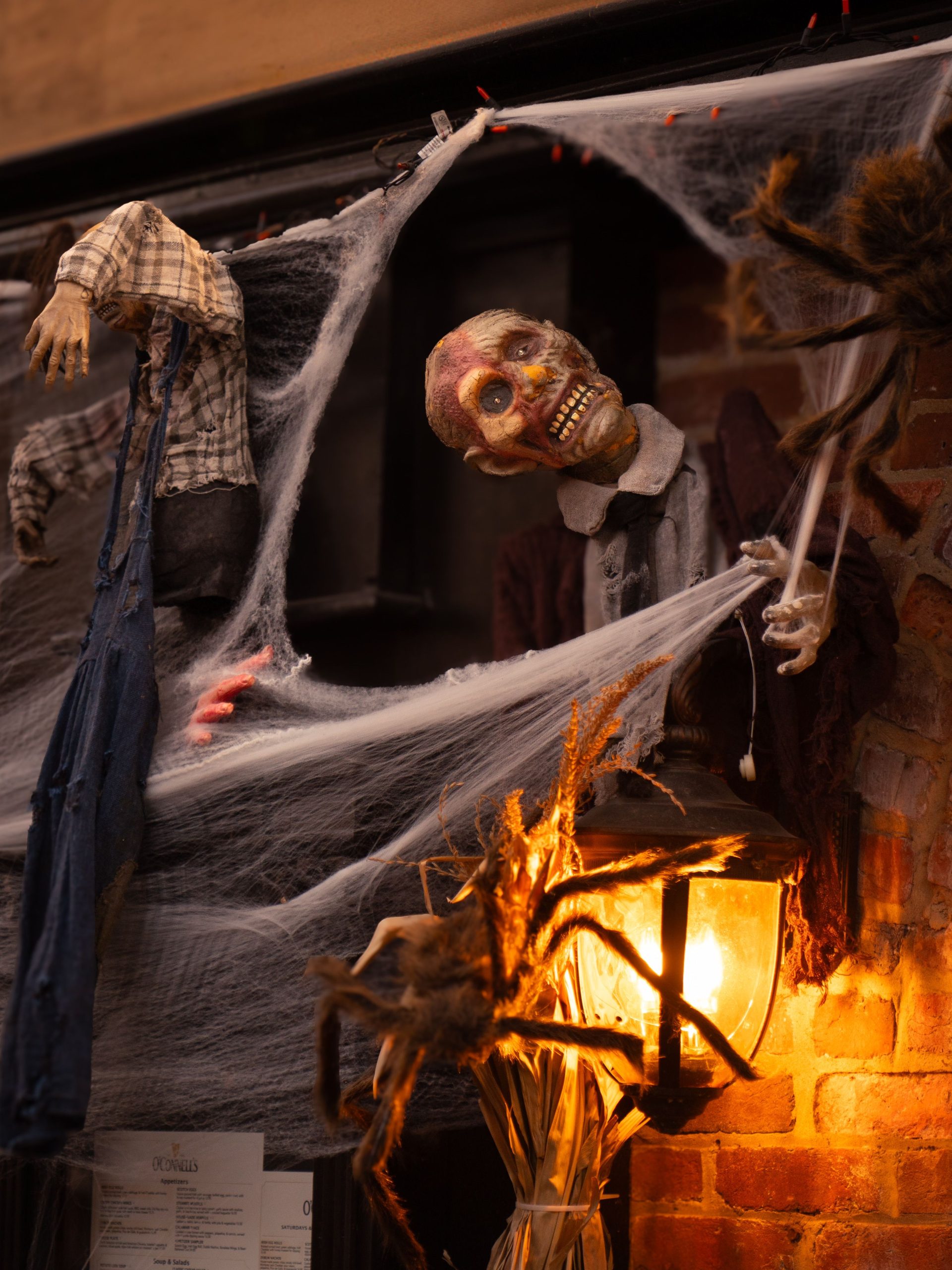 Atmospheric Halloween scene with skeleton, cobwebs, and warm lighting.