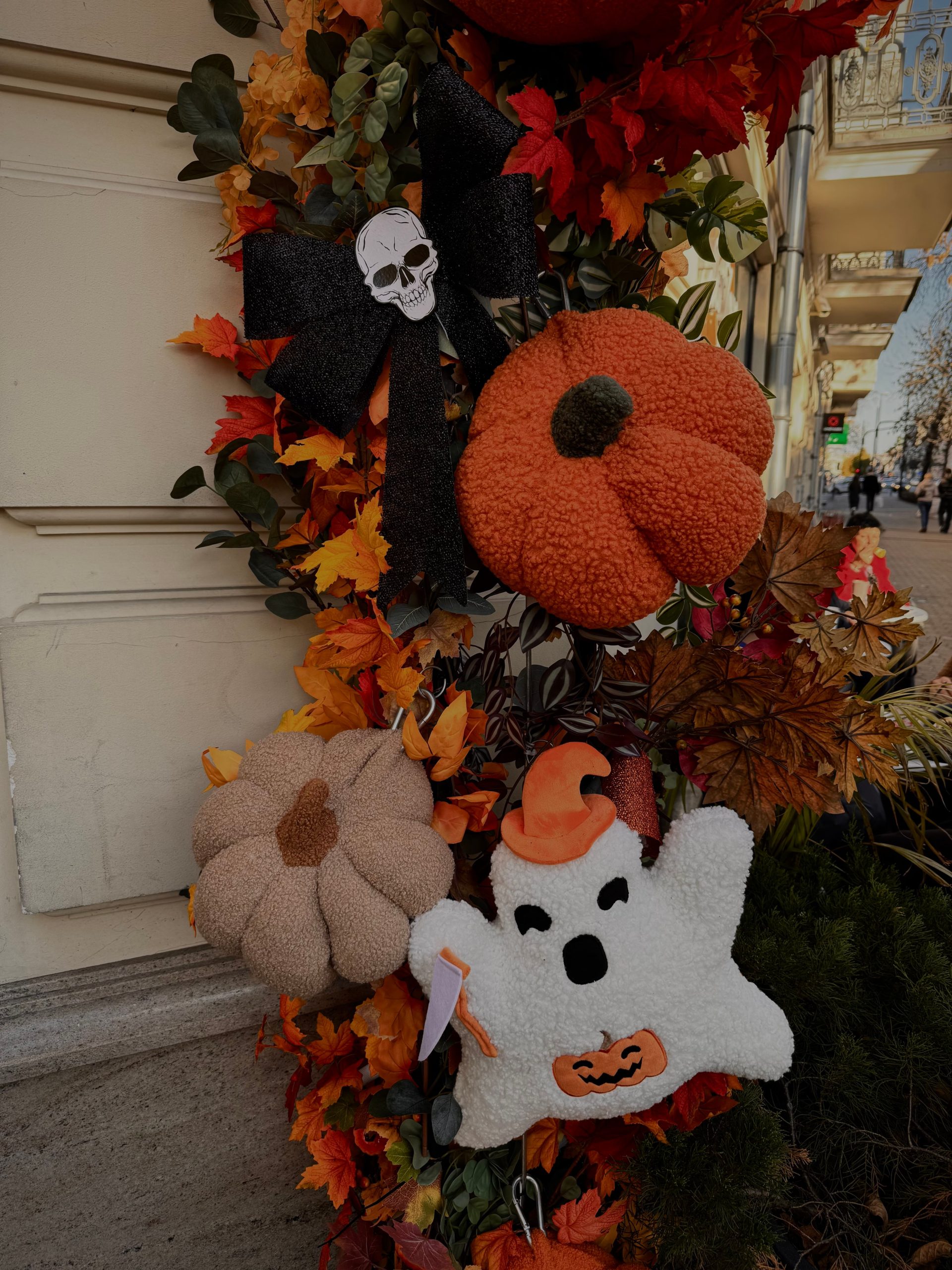 Autumn-themed Halloween decorations including plush pumpkins and a ghost in vibrant fall colors.