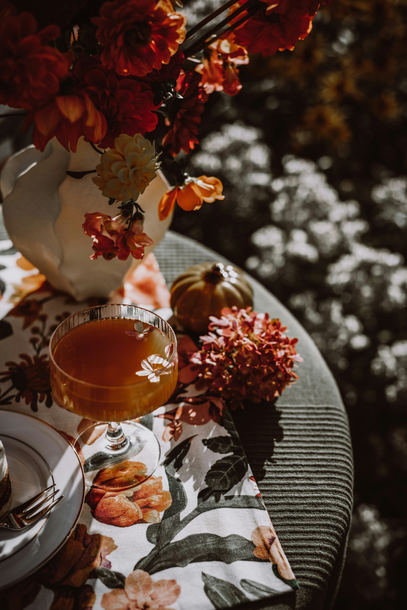 Autumnal drink with flowers and small pumpkins on table
