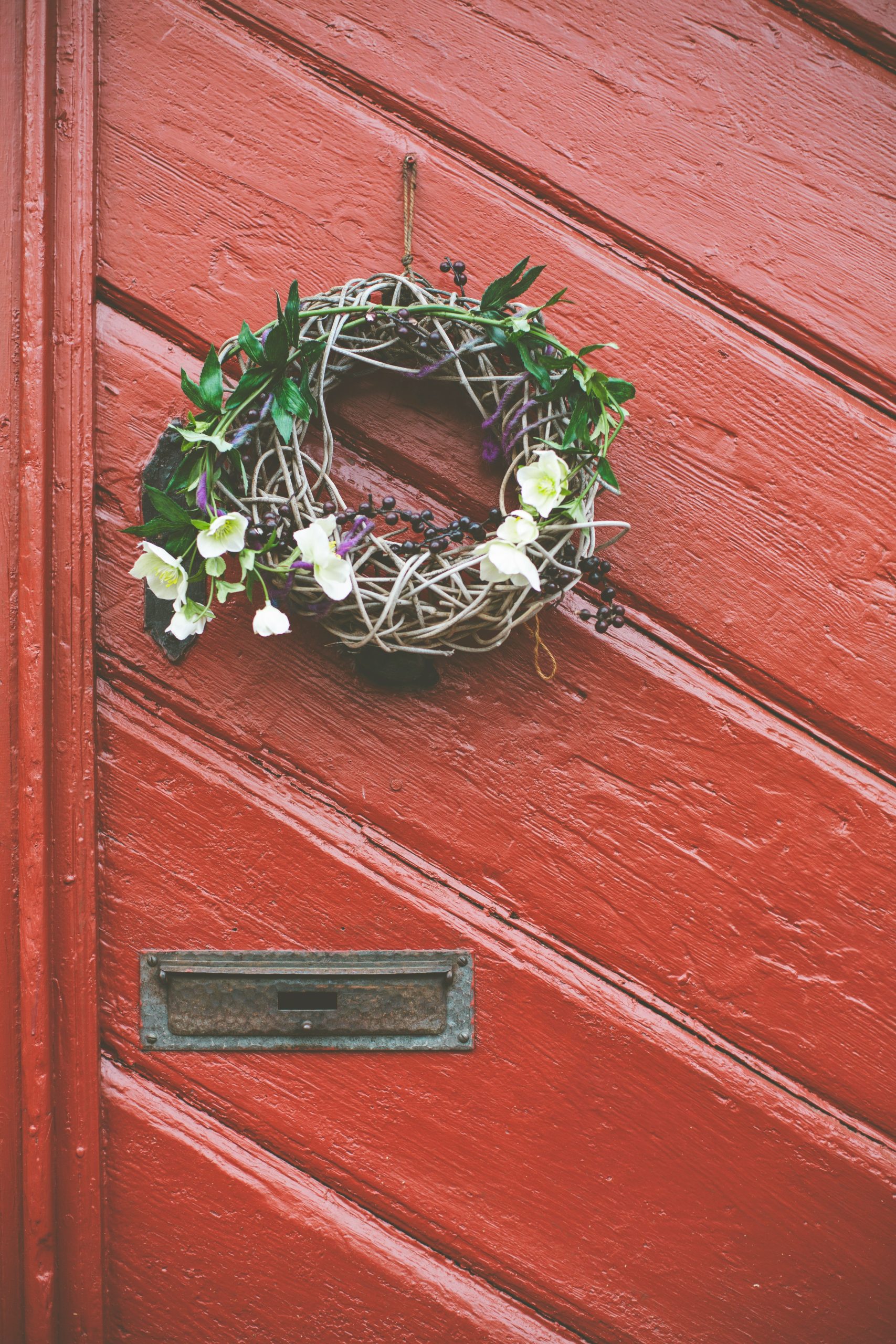 Autumnally floral wreath at vintage weathered wooden red door. Made with Canon 5d Mark III and analog vintage lens, Leica Summilux-R 1.4 50mm (Year: 1983)