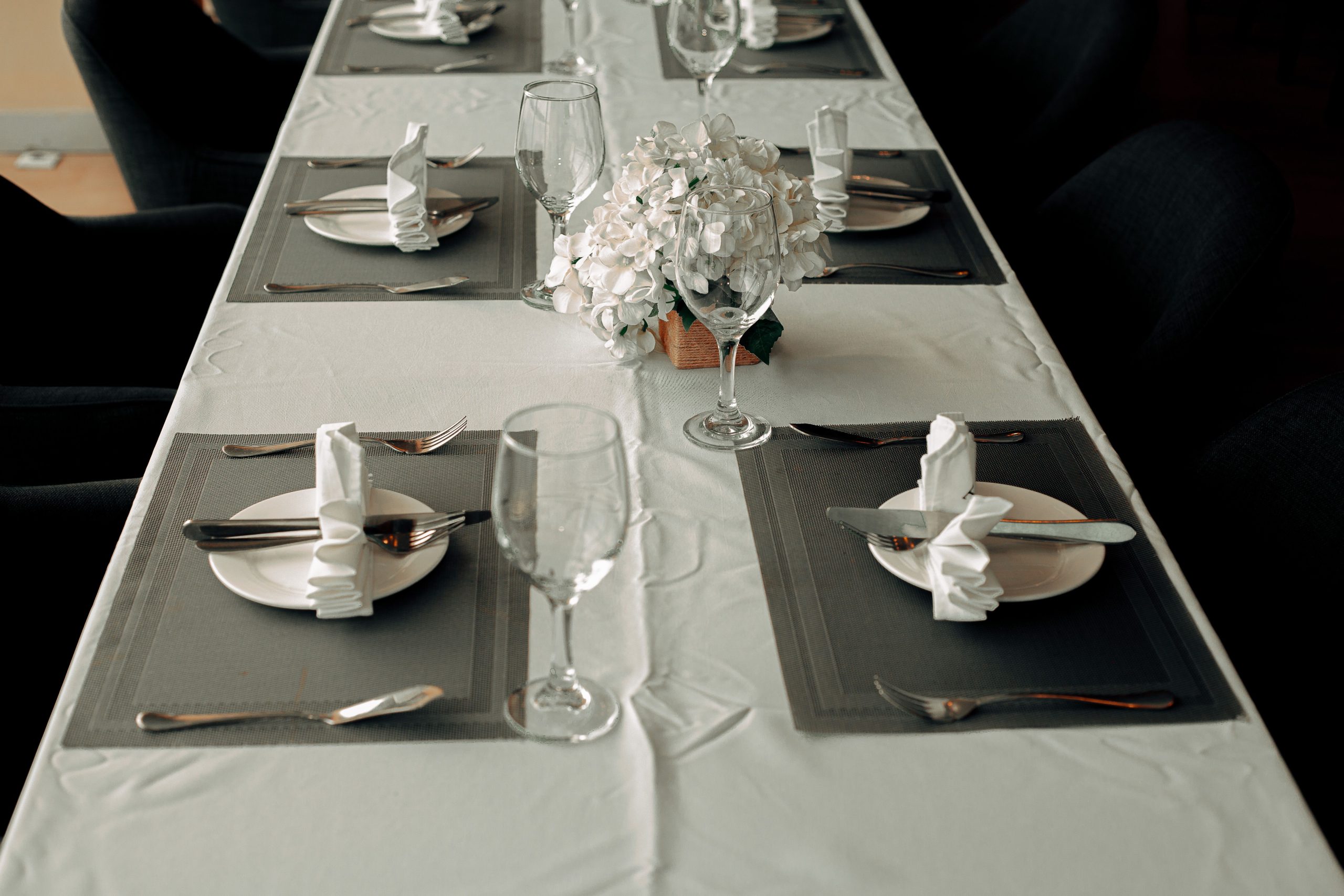 Beautifully arranged formal dining table with elegant tableware and floral centerpiece.