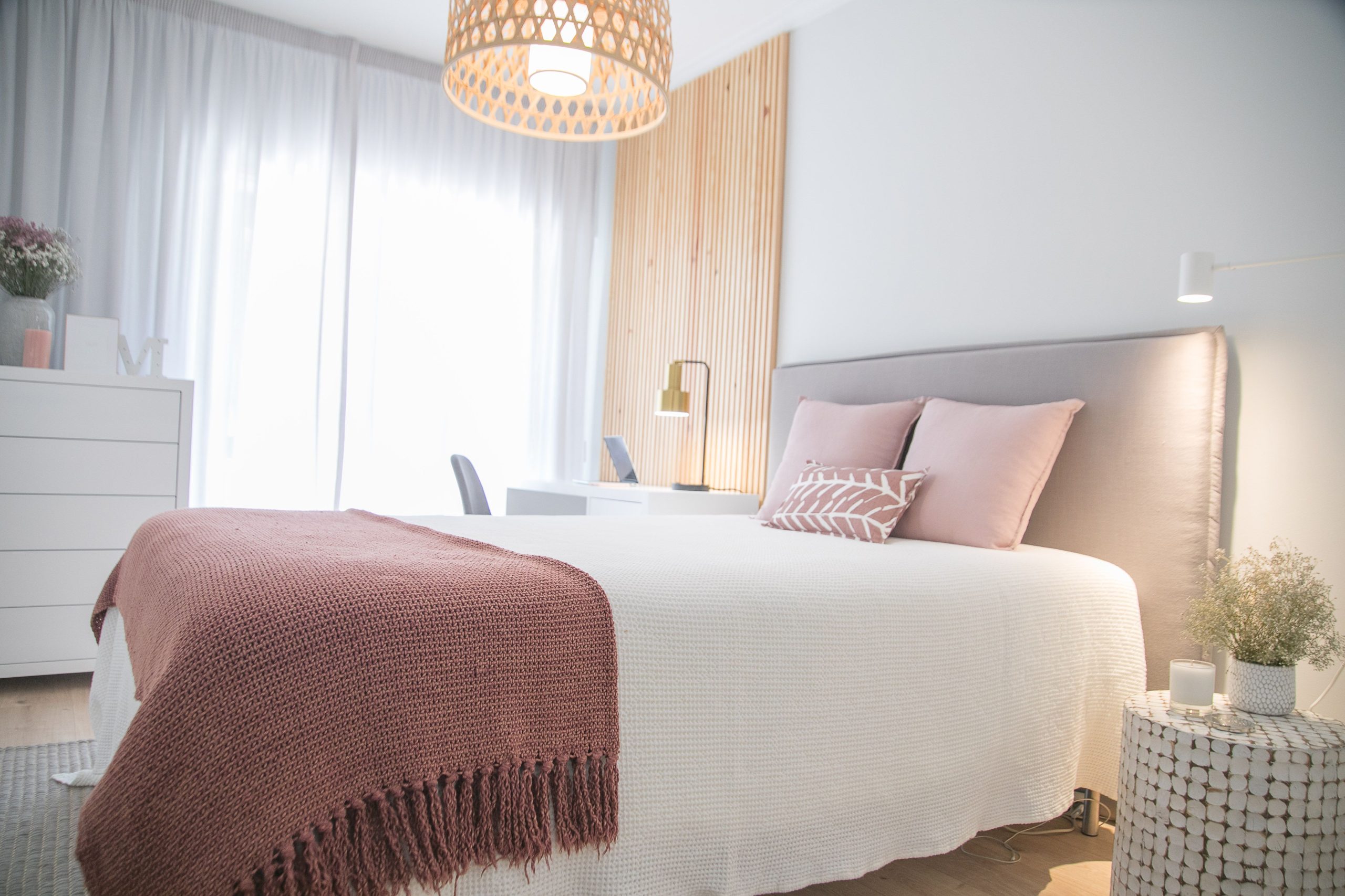 Bright and cozy minimalist bedroom showcasing modern decor with natural light and soft colors.