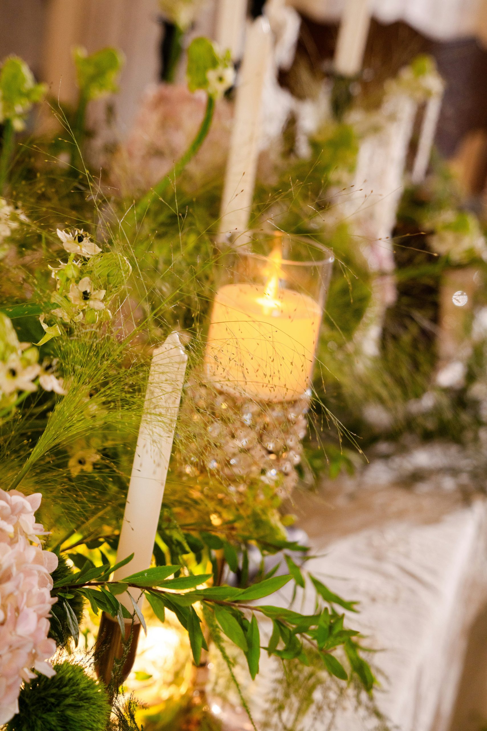 Candles and greenery adorn a festive table setting.