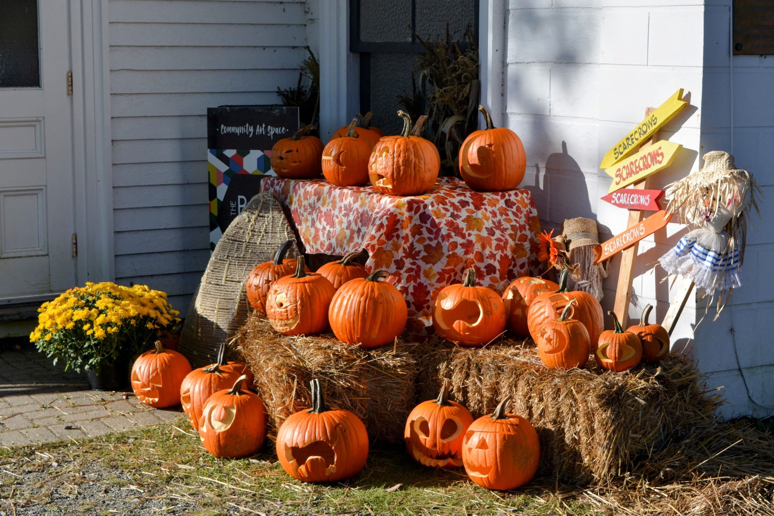 Carved pumpkins on hay bales create a festive Halloween scene in Mahone Bay.