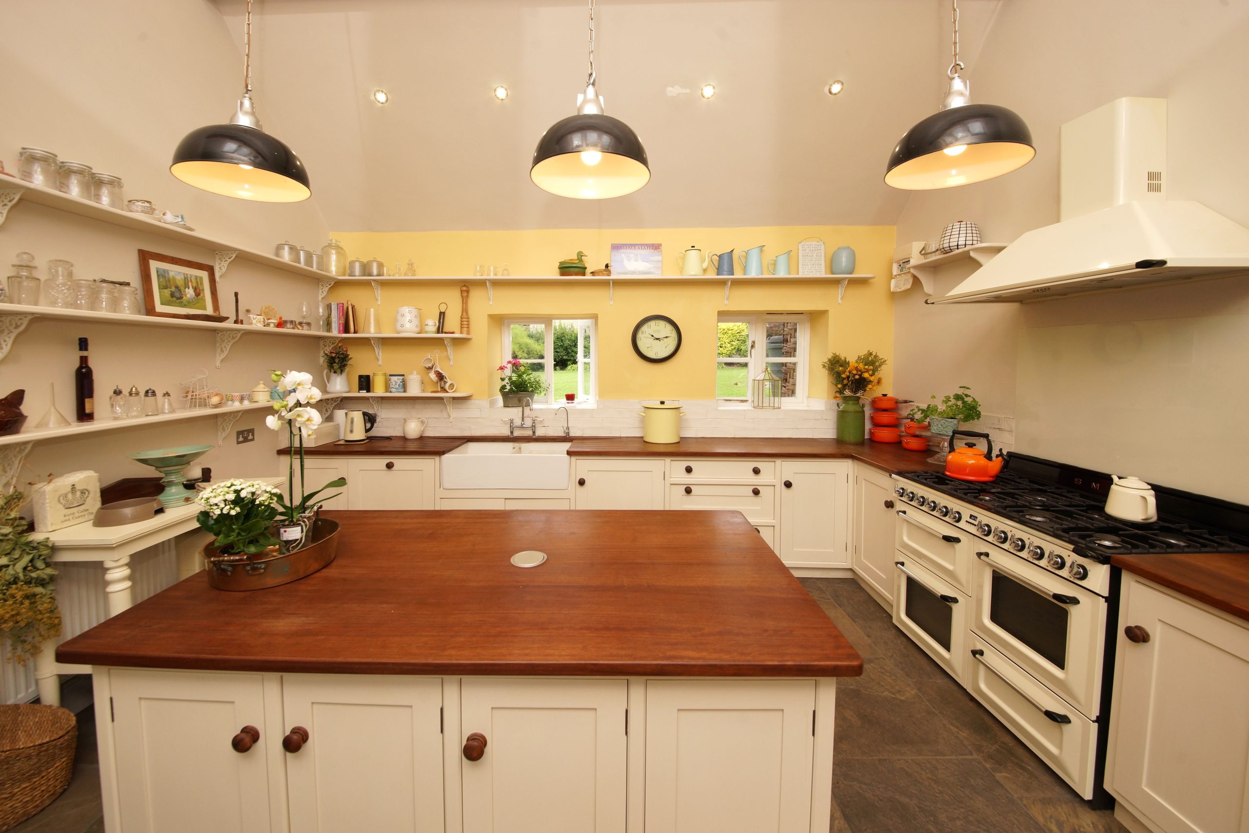 Charming farmhouse kitchen with elegant wood countertops, open shelving, and vintage decor.